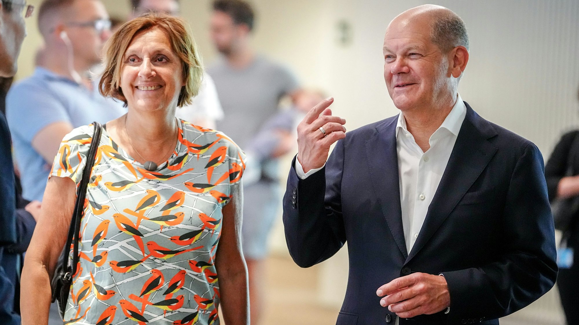 Bundeskanzler Olaf Scholz (r, SPD) steht mit seiner Ehefrau Britta Ernst wartend in einer Schlange in seinem Wahllokal, um seine Stimme für die Europawahl abzugeben.