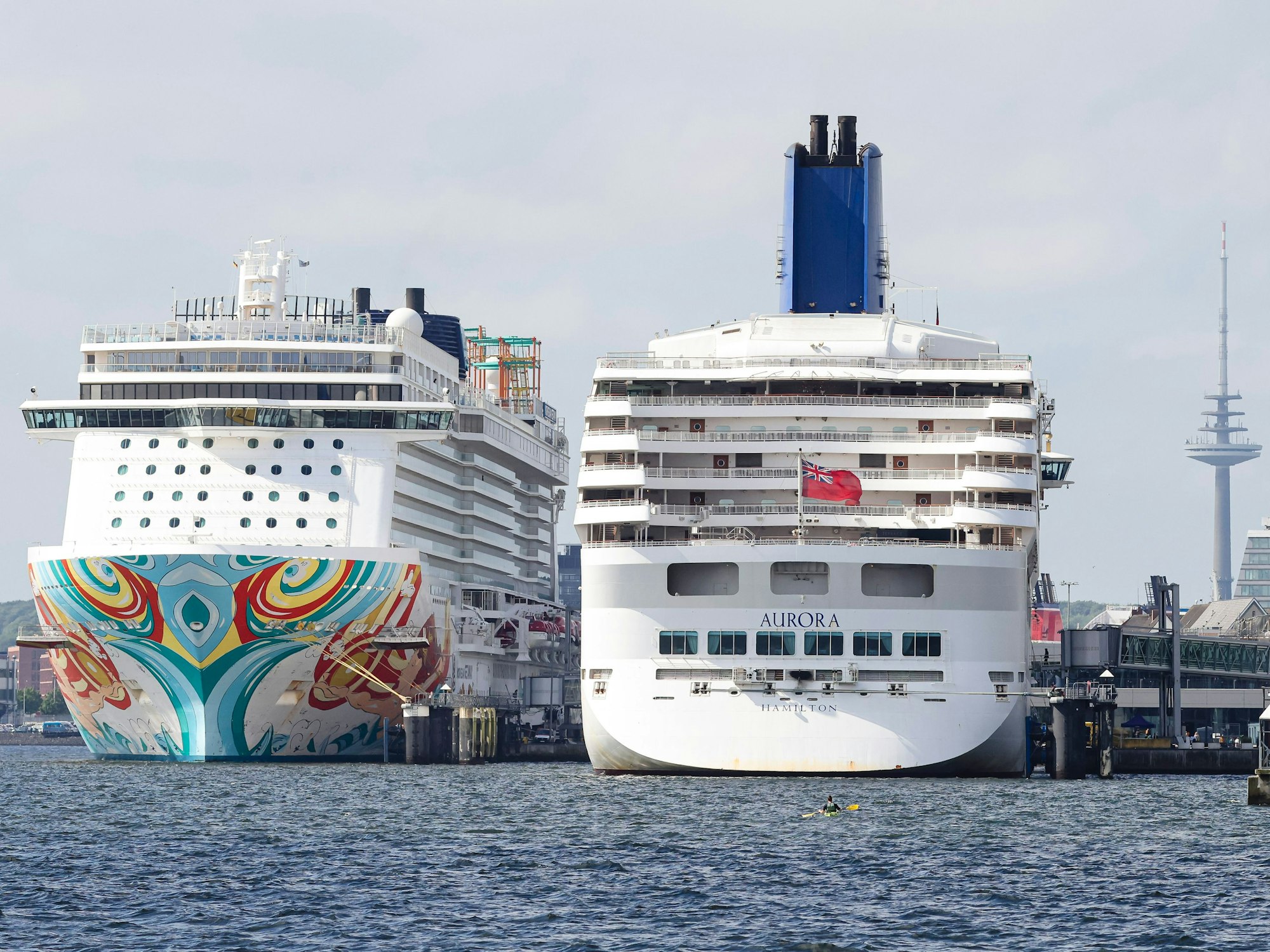 Die Sonne scheint auf die Kreuzfahrtschiffe „Norwegian Getaway“ (l) und „Aurora“ im Hafen der Kieler Förde, hier im Mai 2024. (Symbolbild)