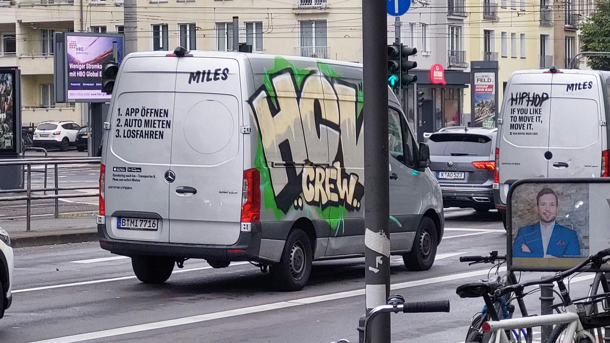Ein Lieferwagen, der auf einer Straße unterwegs ist, wurde seitlich besprüht mit Buchstaben und dem Wort „Crew“.