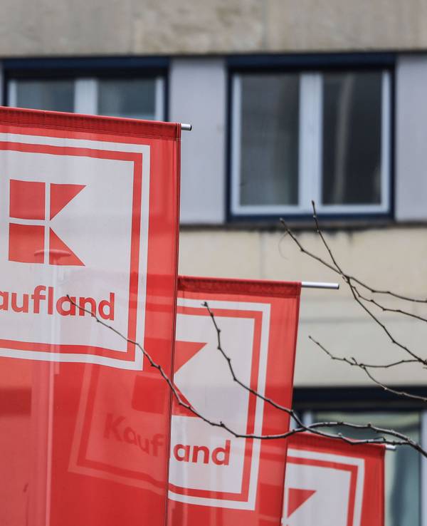 Flaggen von Kaufland hängen vor einer Filiale in Köln-Ehrenfeld.