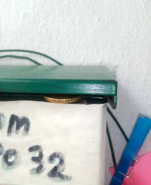 Ein 50-Cent-Stück wurde in die Öffnung eines Briefkastens gelegt.