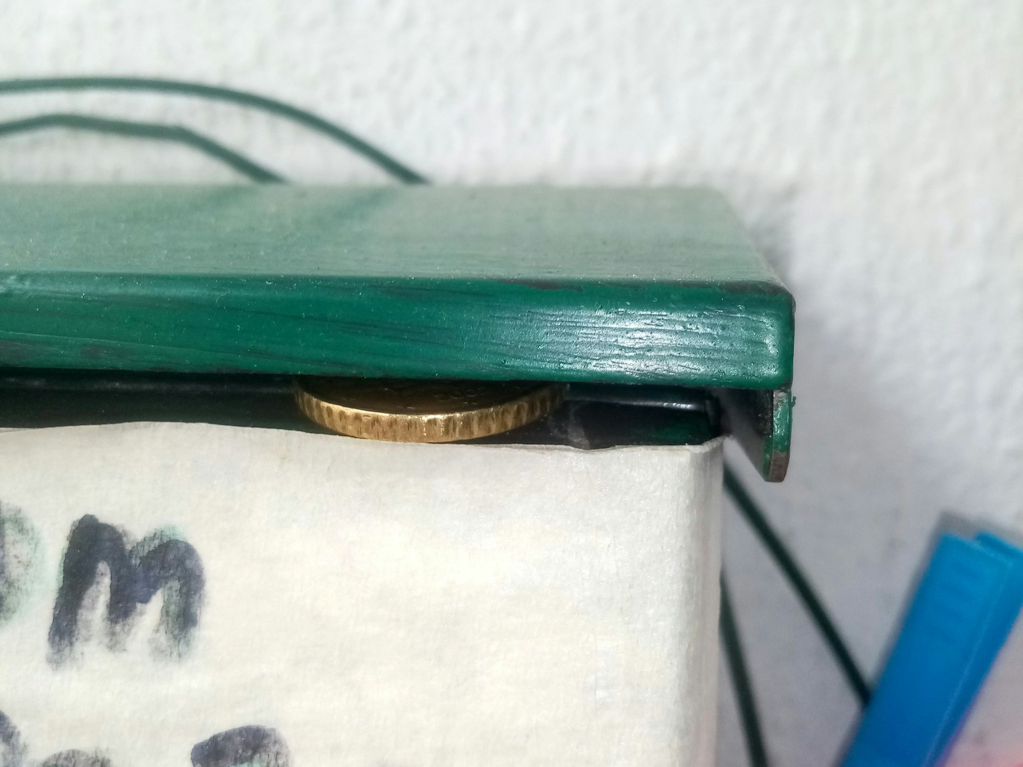 Ein 50-Cent-Stück wurde in die Öffnung eines Briefkastens gelegt.