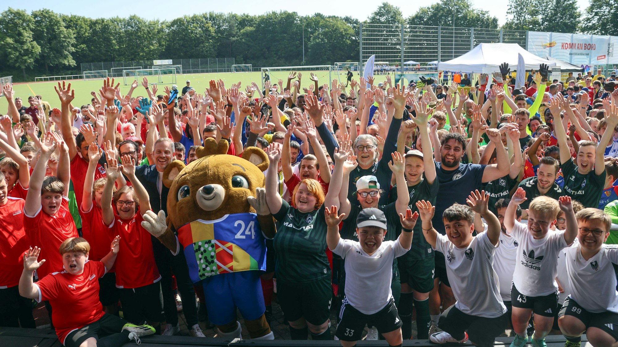 Die Spielerinnen und Spieler beim „Kick2gether Euro Cup“ in Zündorf jubeln in die Kamera.
