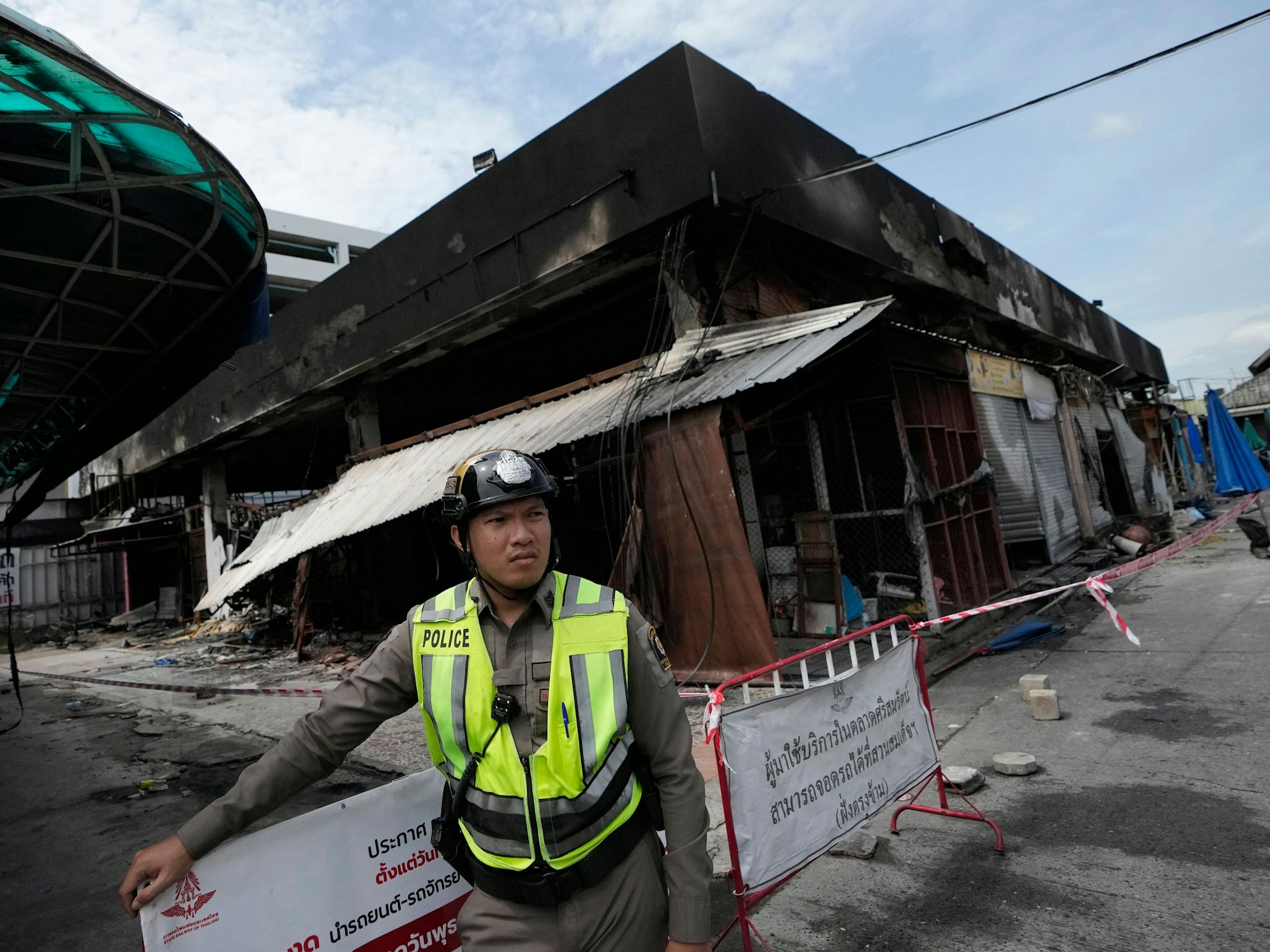 Ein thailändischer Polizist steht nach dem Brand auf dem Chatuchak-Wochenendmarkt neben dem Bereich für Haustiere.