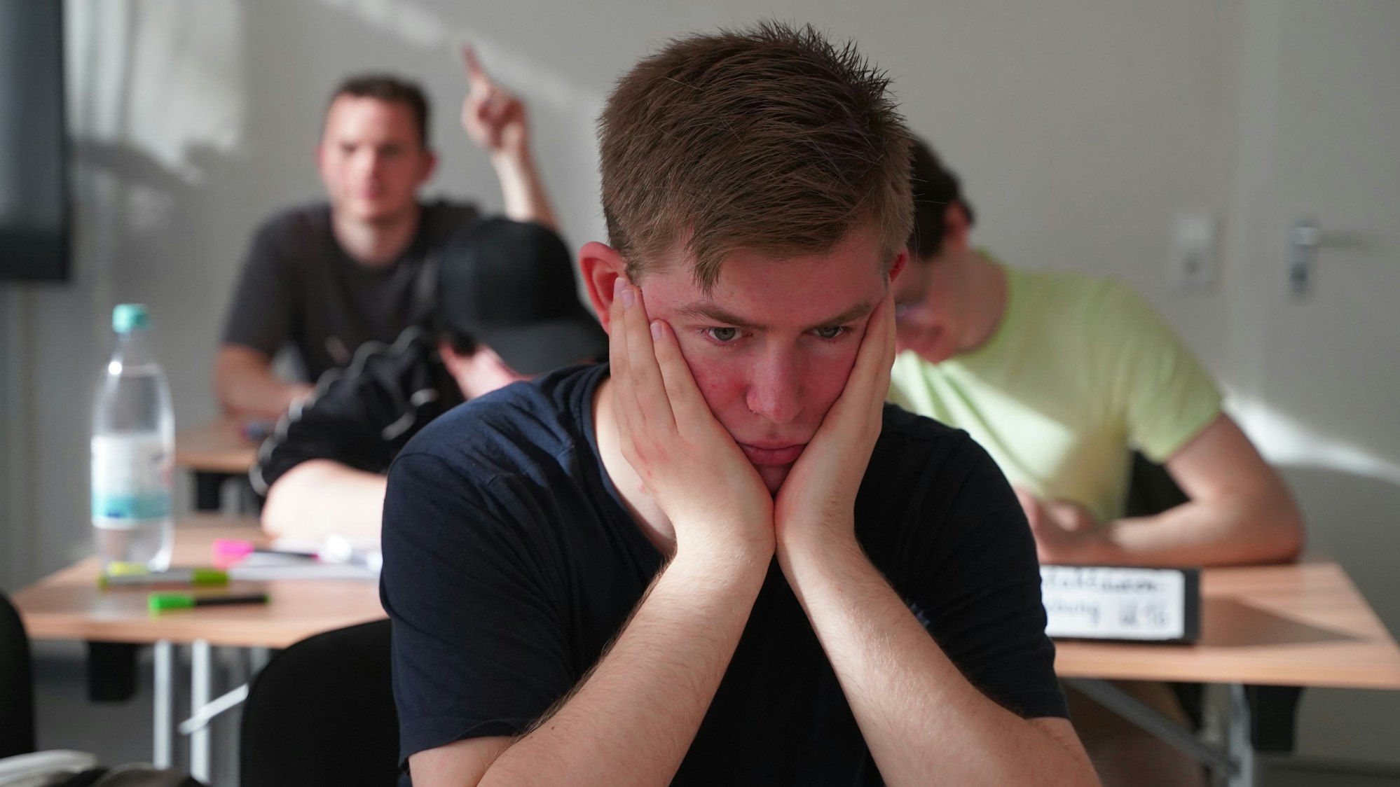 Ein Schüler sitzt traurig im Klassenzimmer.