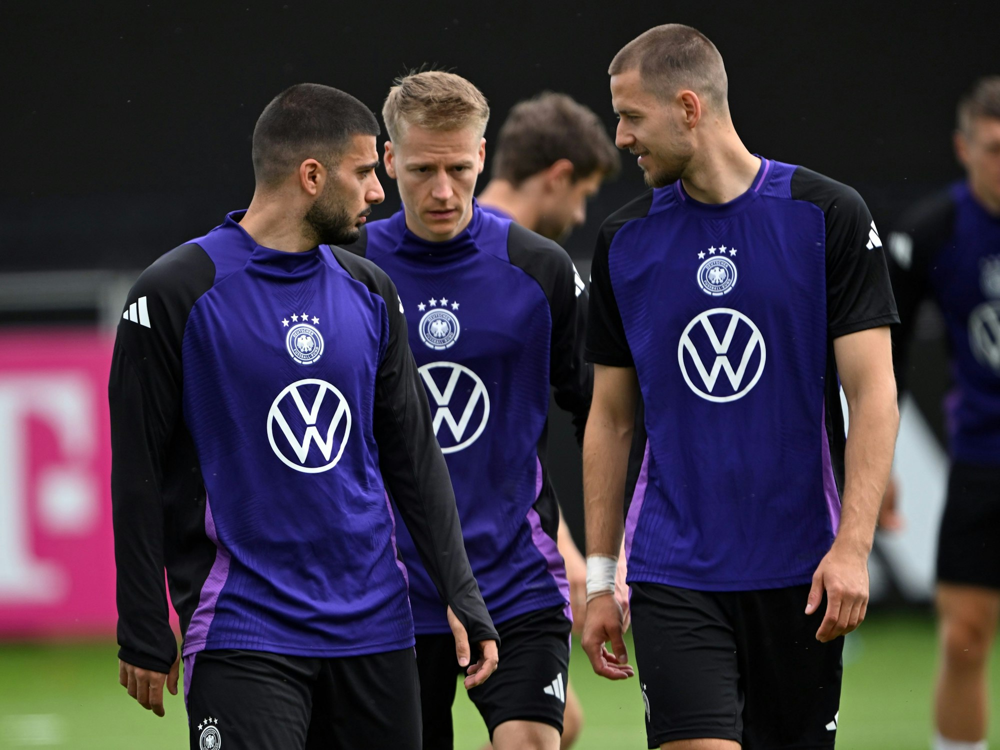 Deutschlands Deniz Undav (l-r), Chris Führich und Waldemar Anton unterhalten sich während des Trainings.