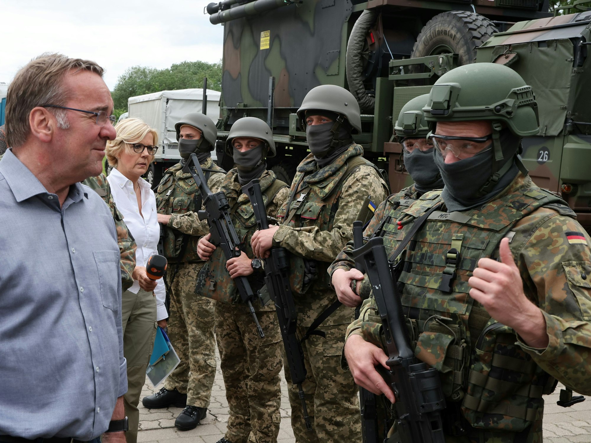 Boris Pistorius (SPD, links), Bundesverteidigungsminister, informiert sich bei einem Besuch der Flugabwehrraketengruppe 21 auf einem Truppenübungsplatz in Mecklenburg-Vorpommern über die Ausbildung ukrainischer Soldaten an dem bodengebundenen Luftverteidigungssystem Patriot und spricht dabei mit einem Soldaten der Bundeswehr.