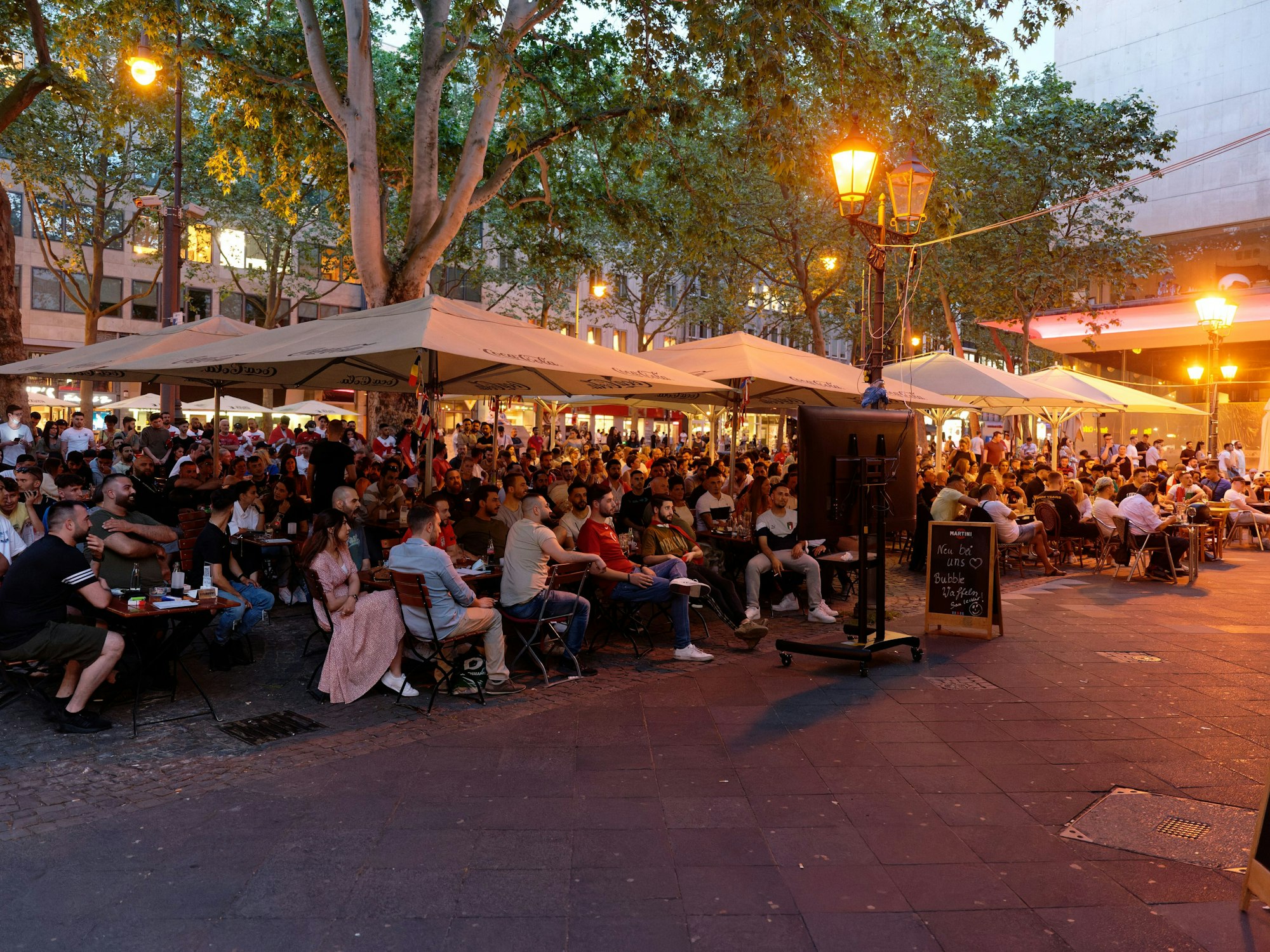 Fußball-Fans schauen ein EM-Spiel auf den Kölner Ringen.