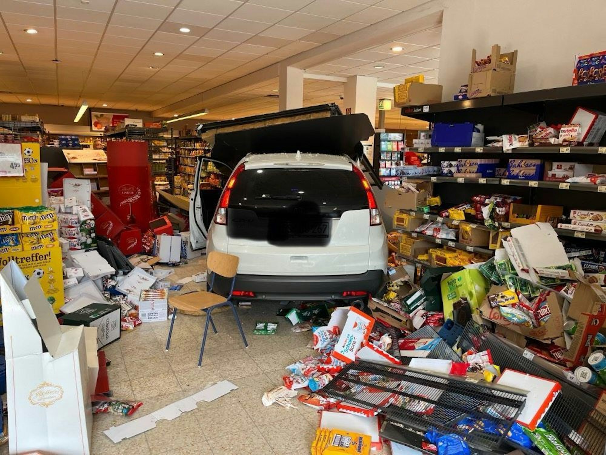 Ein Auto steht auf der Verkaufsfläche eines Einkaufsmarktes. Die Fahrerin des Wagens war mit ihrem Auto durch eine Wand hindurch in den Supermarkt gefahren. Verletzt wurde bei dem Unfall niemand.