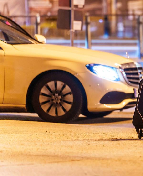 Eine Frau wartet am Hauptbahnhof auf ein Taxi.