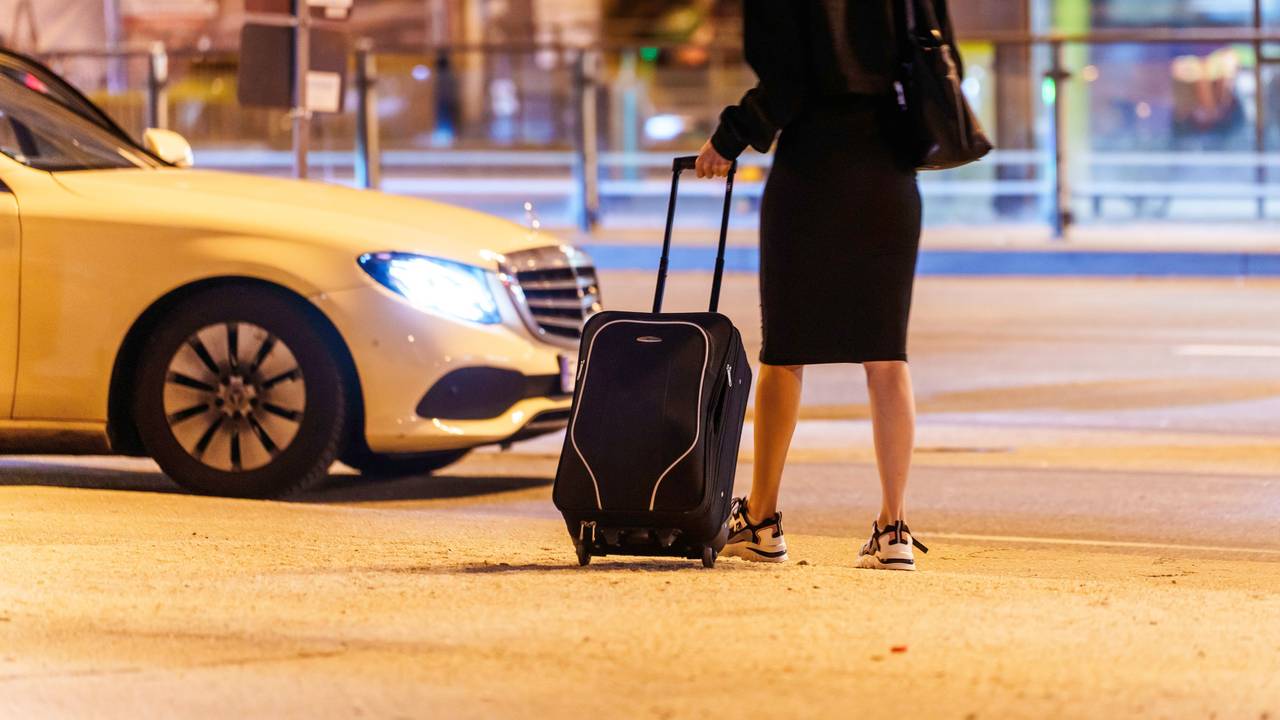 Eine Frau wartet am Hauptbahnhof auf ein Taxi.