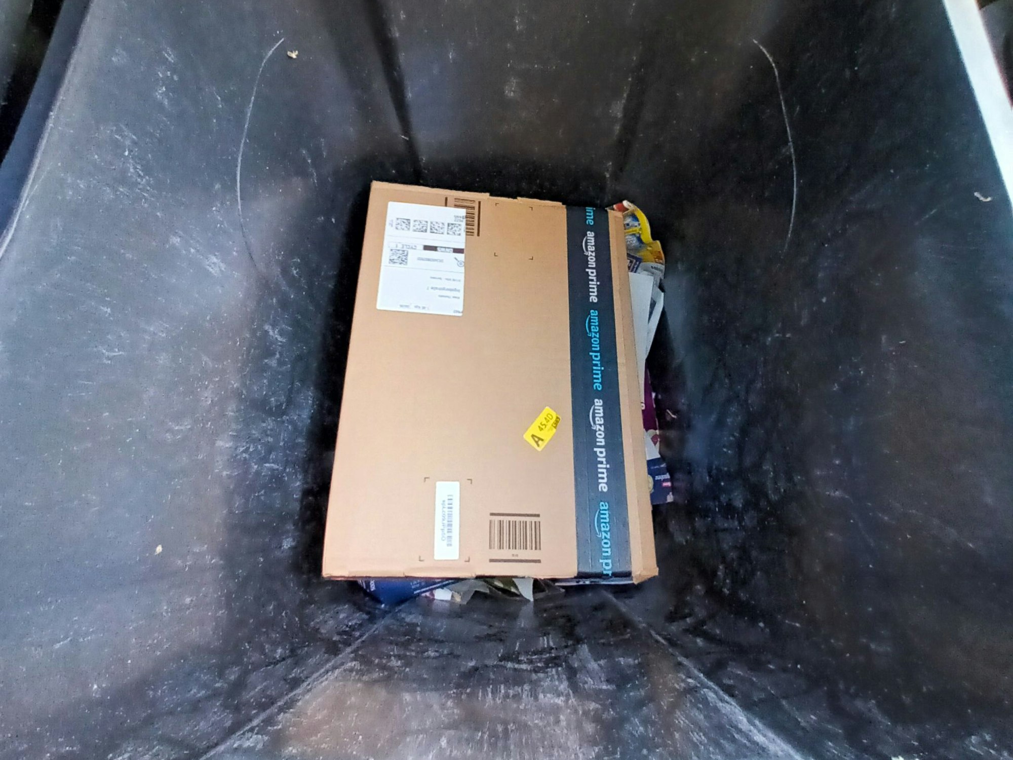 Foto eines Amazon-Pakets in einer Mülltonne.