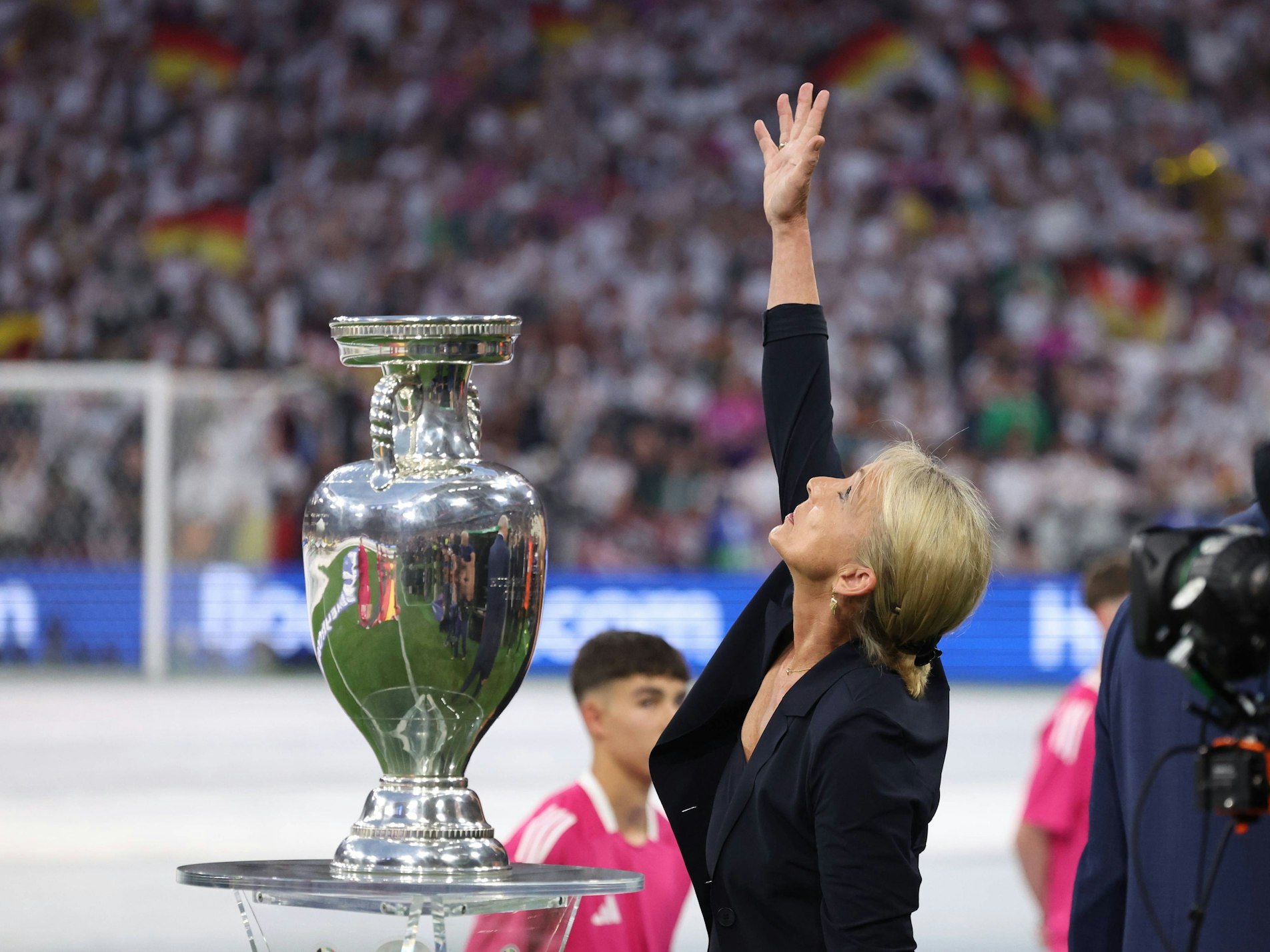 Heidi Beckenbauer greift zum Ende der Eröffnungsfeier der EM 2024 Richtung Himmel zu ihrem verstorbenen Ehemann Franz Beckenbauer.