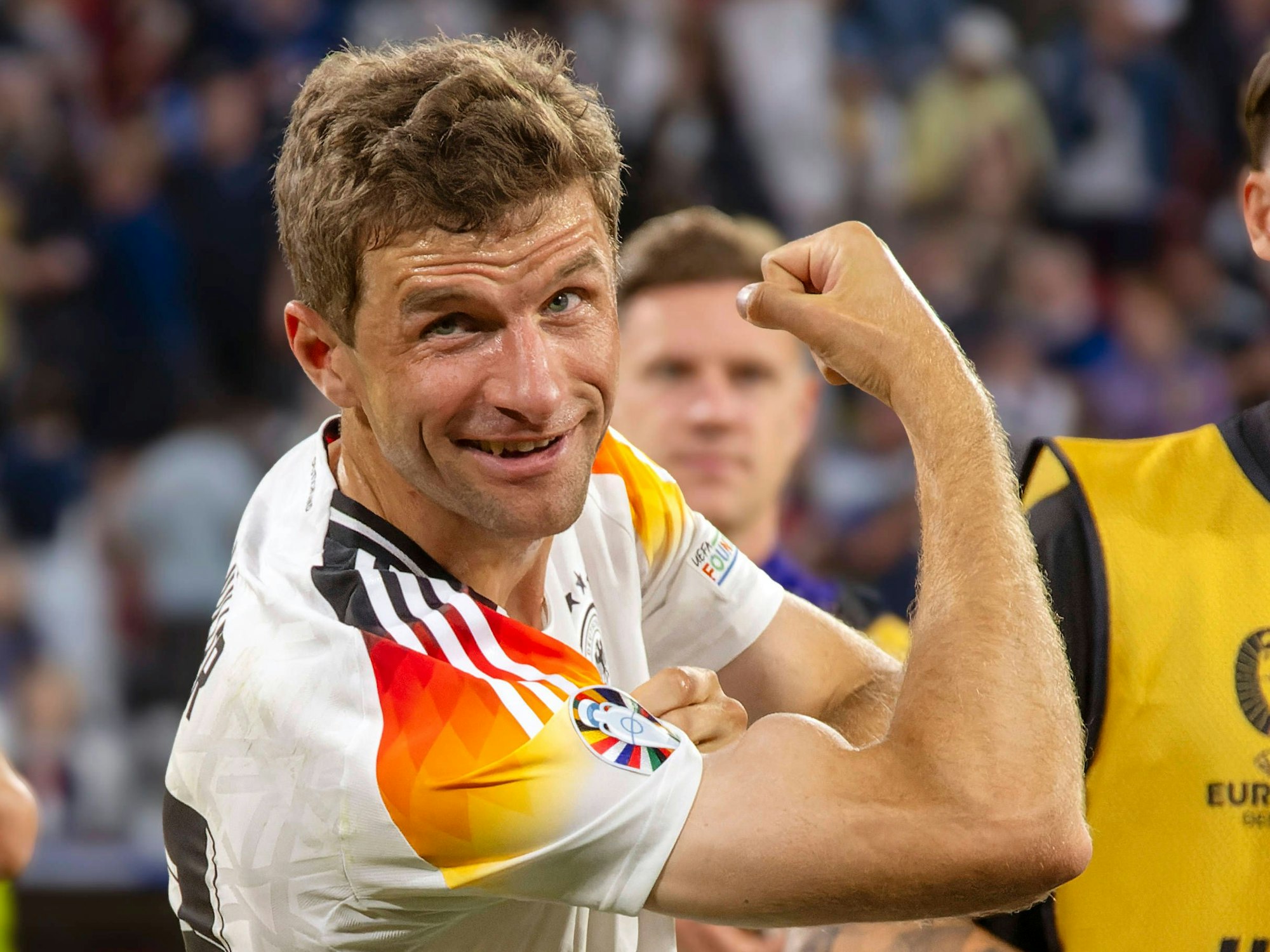 Thomas Müller zeigt nach dem EM-Auftaktsieg gegen Schottland am 14. Juni 2024 seinen Bizeps der Kamera. Dieser sieht aus wie eine große Beule am Arm.