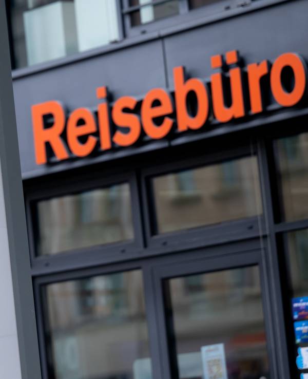 Das Logo des Reiseveranstalters FTI vor einem Reisebüro