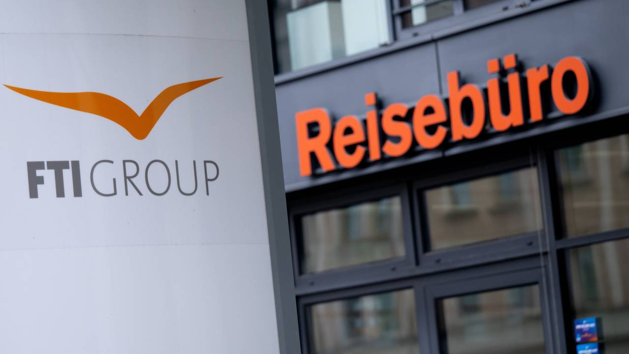 Das Logo des Reiseveranstalters FTI vor einem Reisebüro