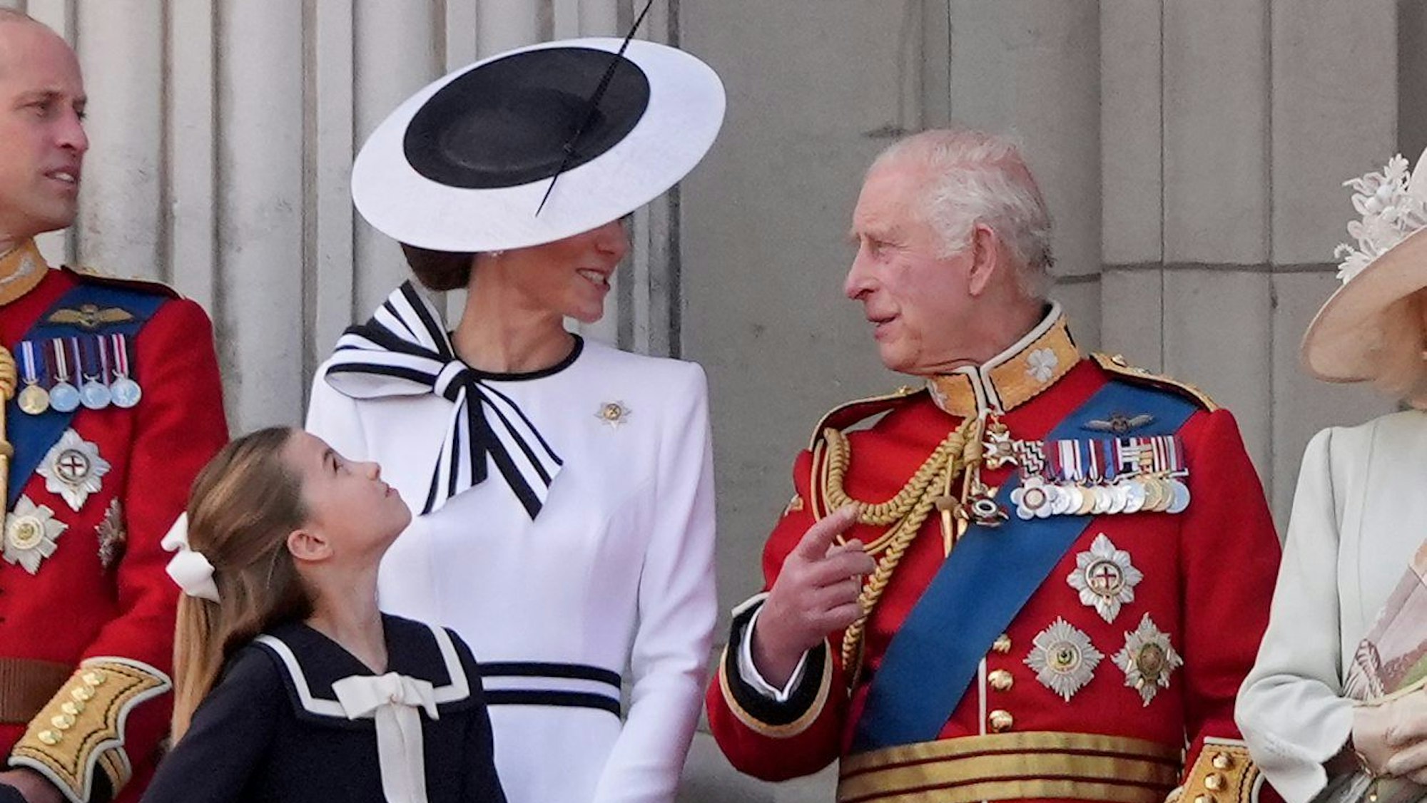 König Charles III spricht mit Prinzessin Kate. Sie stehen auf dem Balkon vom Buckingham Palace.