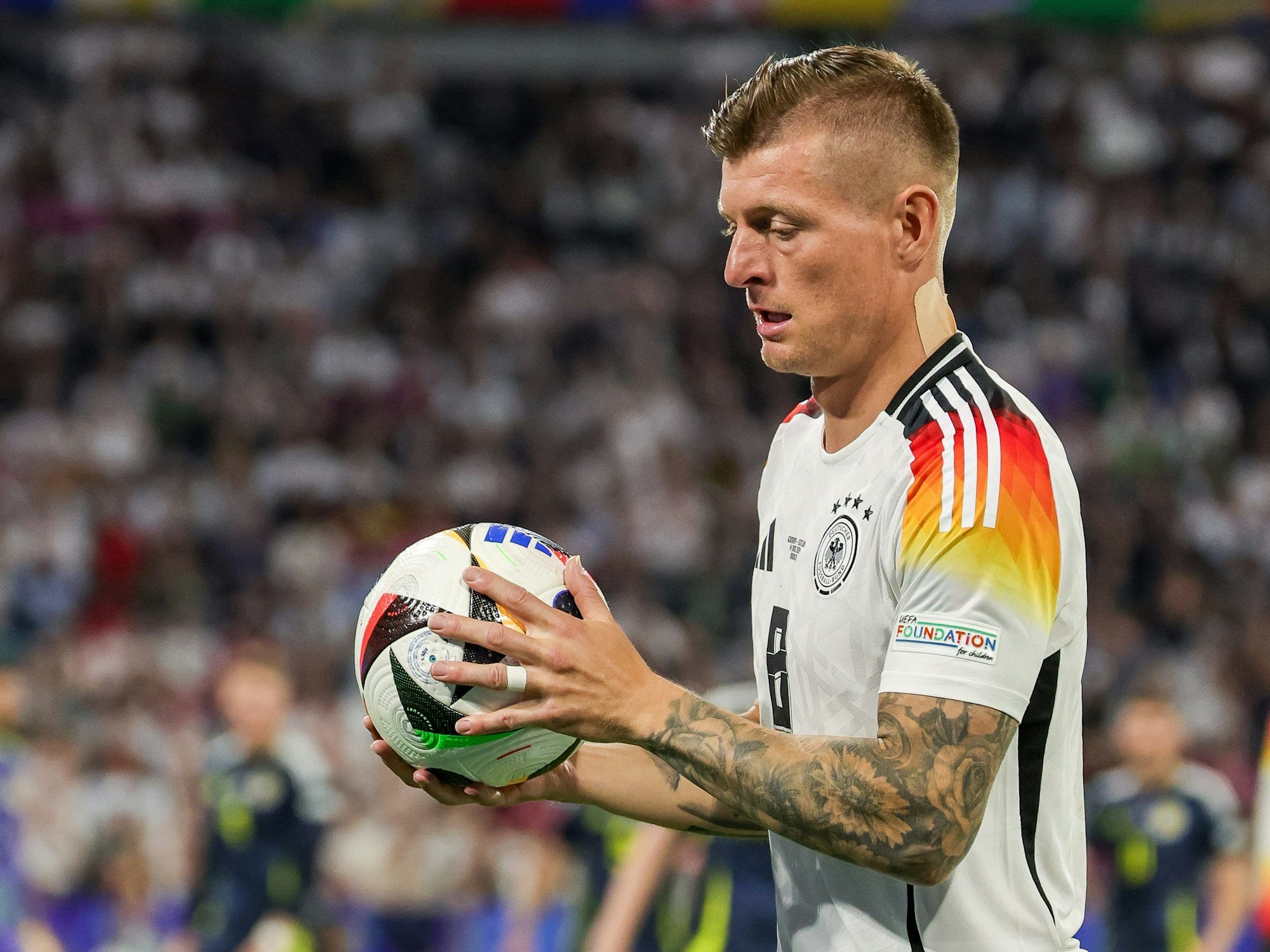 Deutschlands Toni Kroos hat den Ball in der Hand.