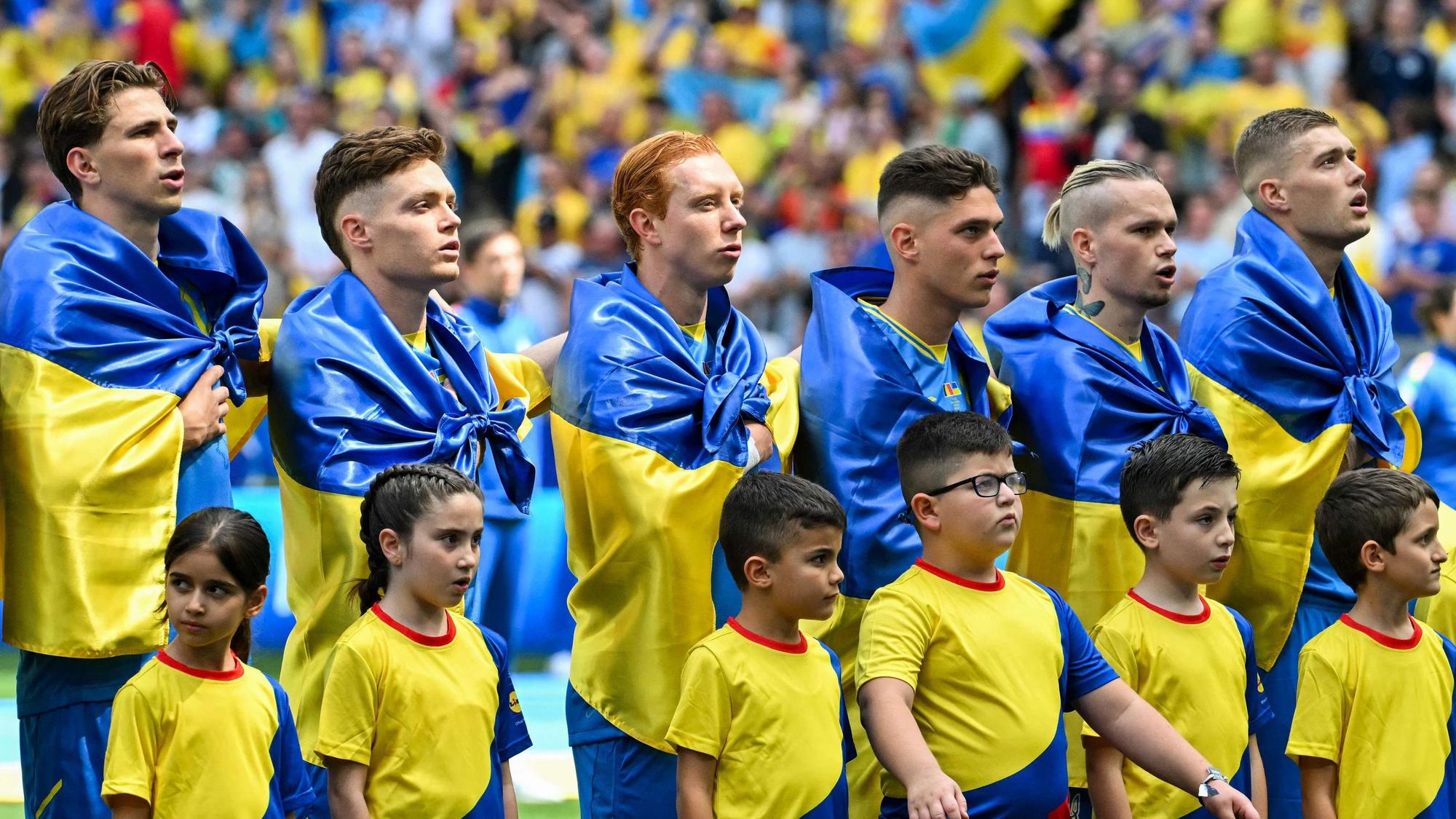 Die ukrainischen Spieler mit Flaggen um die Schultern bei der Hymne.