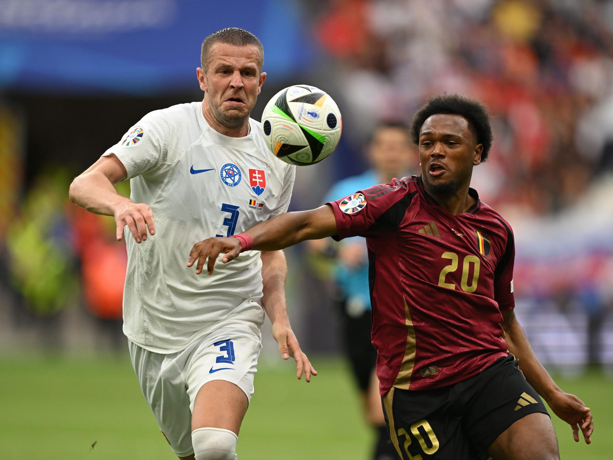 Denis Vavro von der Slowakei und Belgiens Lois Openda (r) kämpfen um den Ball.