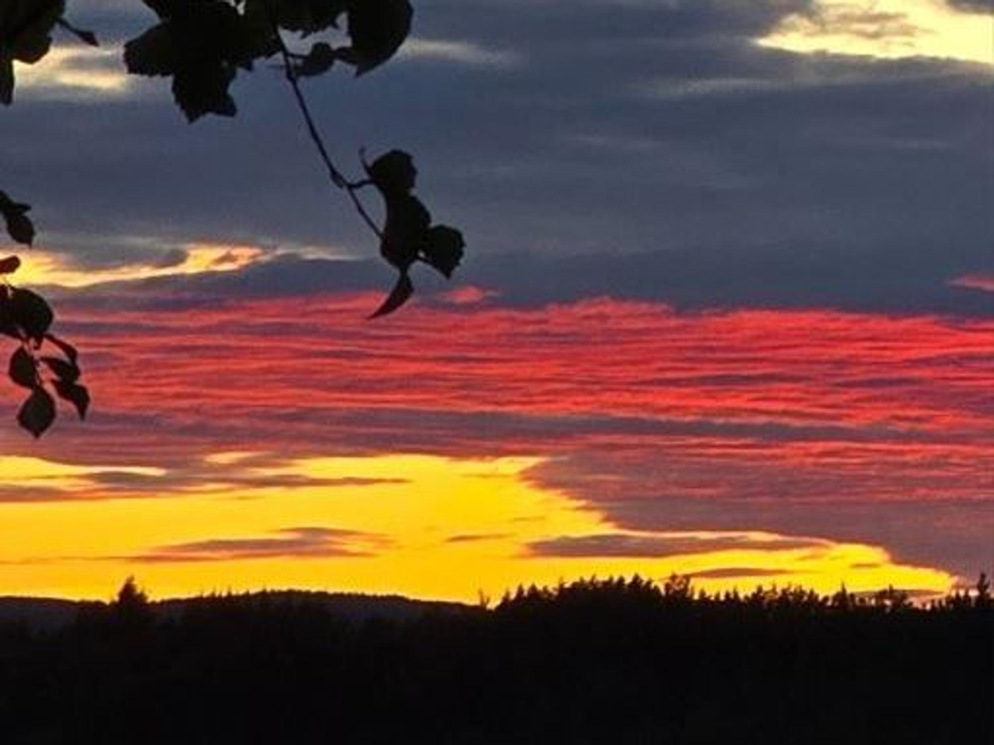 Am Himmel sind Wolken zu sehen, die sich farblich zu einer Deutschland-Fahne bündeln.