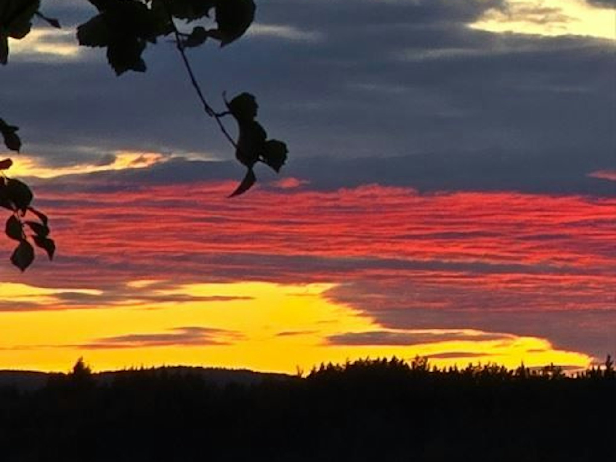 Am Himmel sind Wolken zu sehen, die sich farblich zu einer Deutschland-Fahne bündeln.