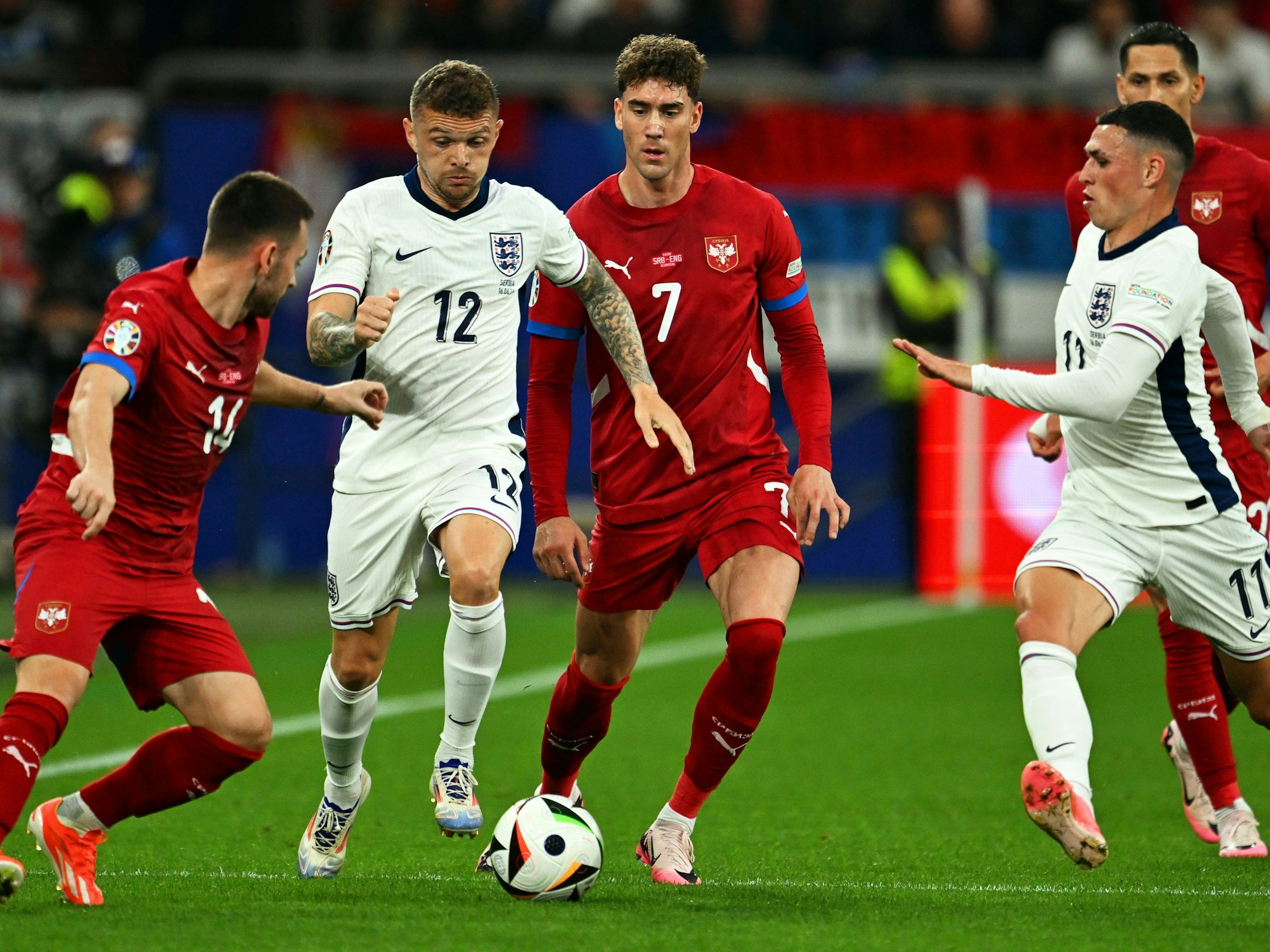 Englands Spieler Kieran Trippier (2.v.l) und Phil Foden (r) in Aktion gegen Serbiens Spieler Andrija Zivkovic (l) und Dusan Vlahovic (2.v.r).