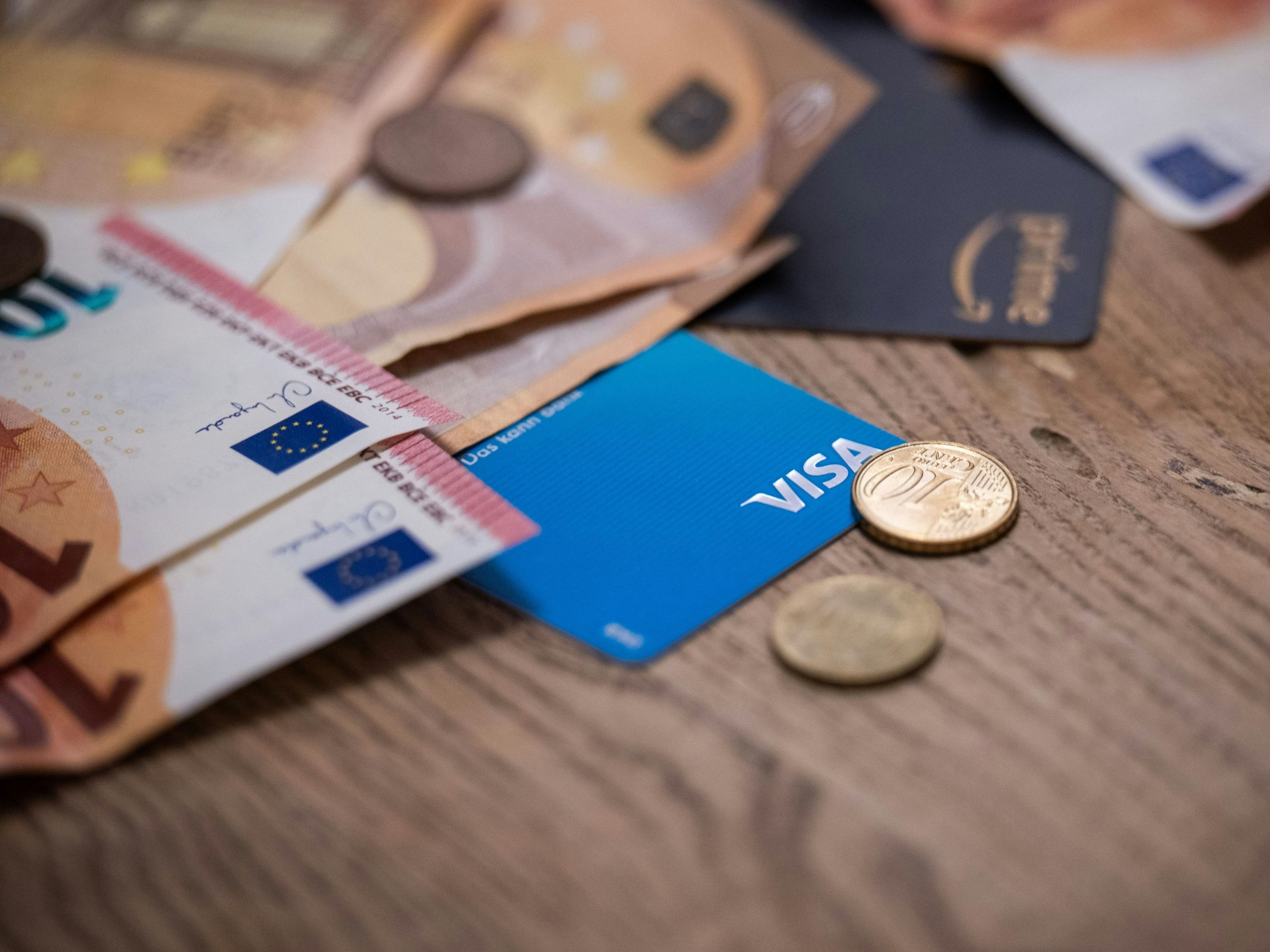 Geldscheine, Münzen und Bankkarten liegen auf einem Tisch, hier im November 2023 in Berlin.