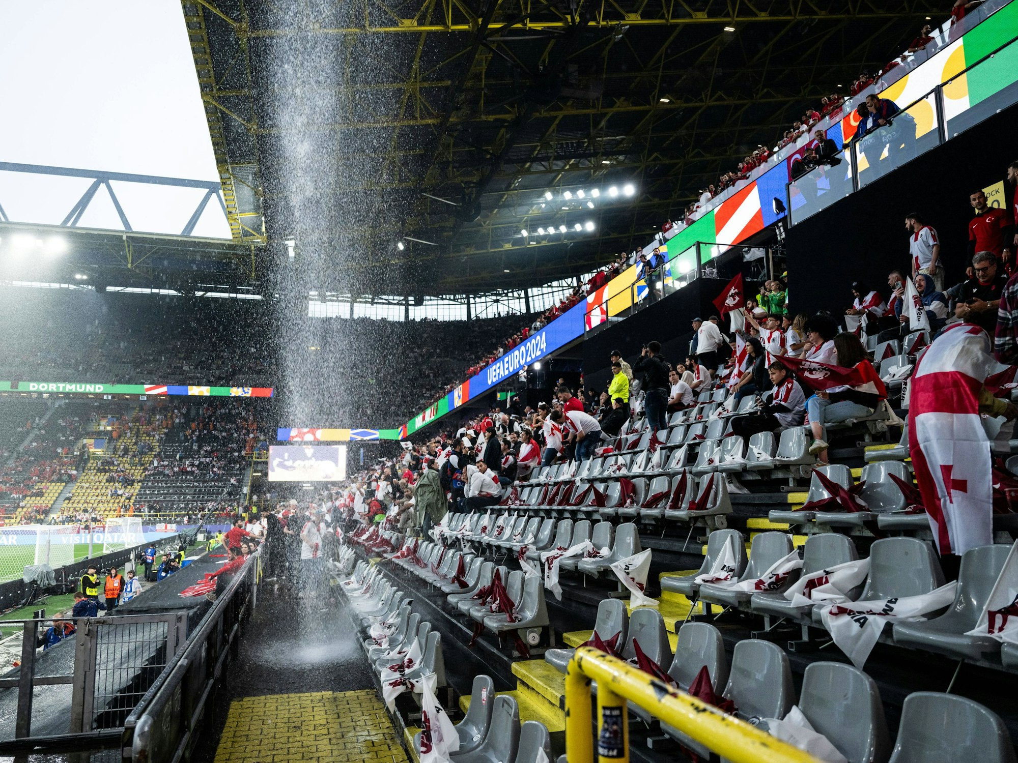 Ein Wasserfall prasselt vom Dach des Stadions in Dortmund auf die Fan-Tribüne.