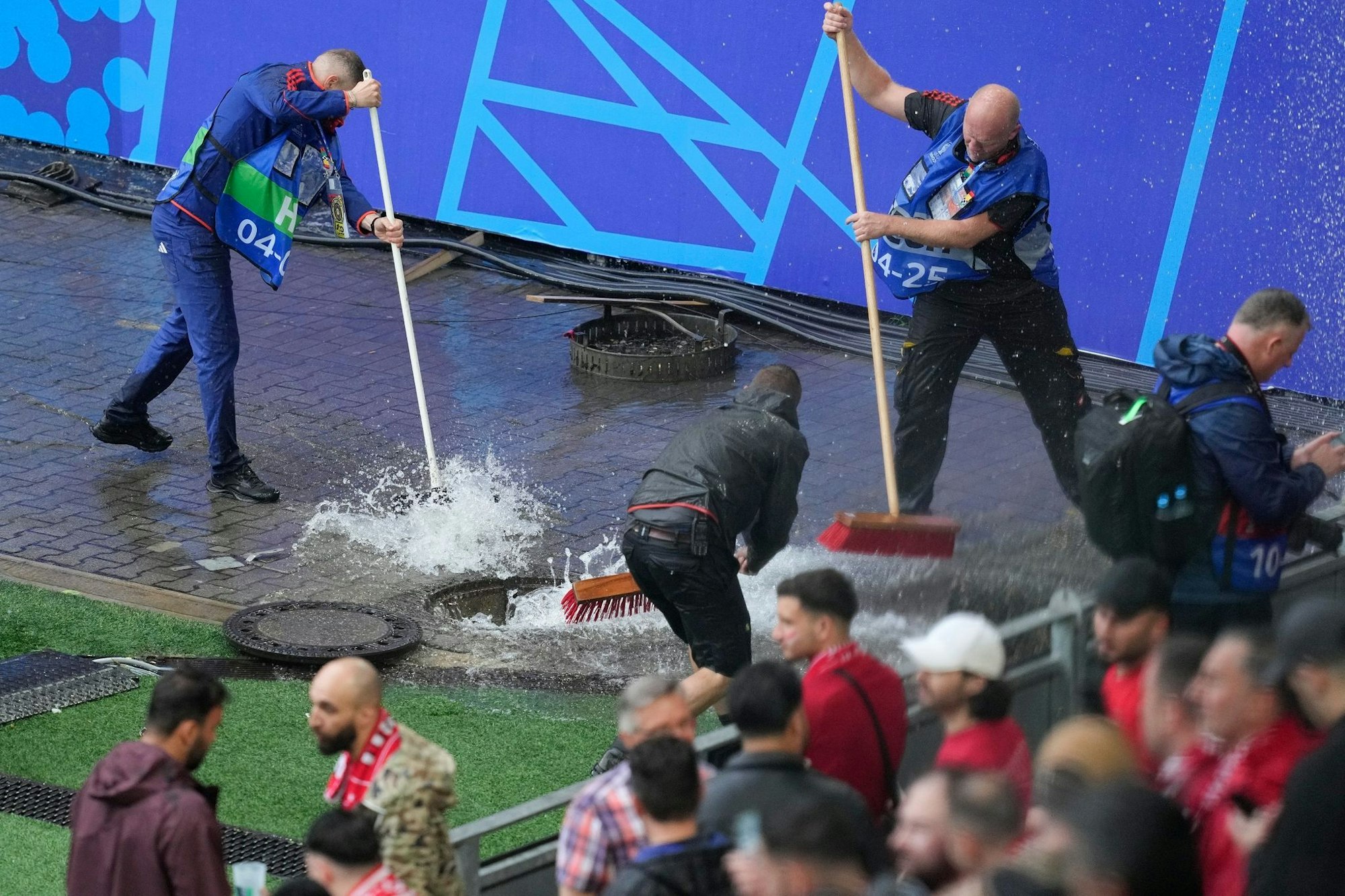 Kampf gegen die Wassermassen: Mitarbeiter sind vor dem Spiel Türkei gegen Georgien im Stadion im Einsatz.