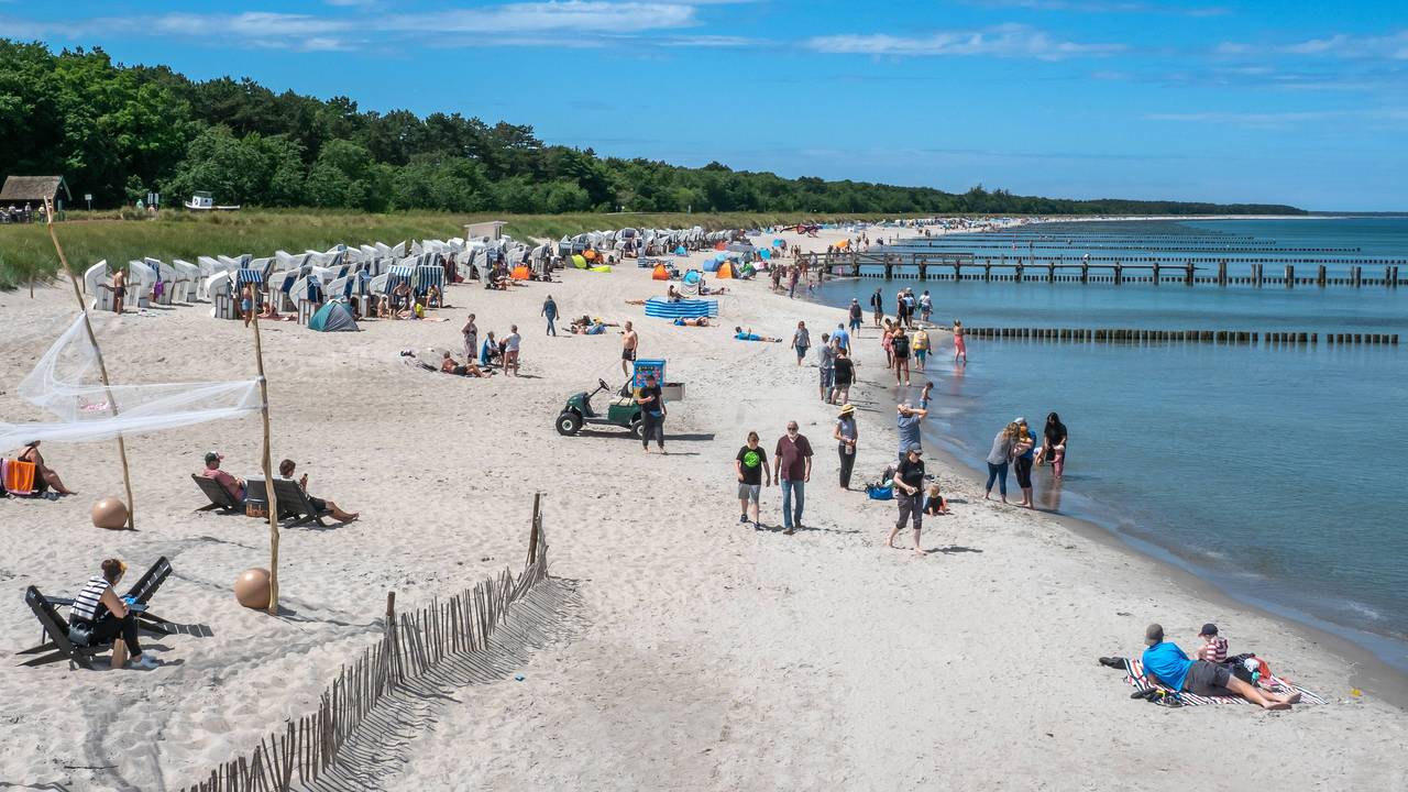 Menschen liegen an der Ostsee am Strand.