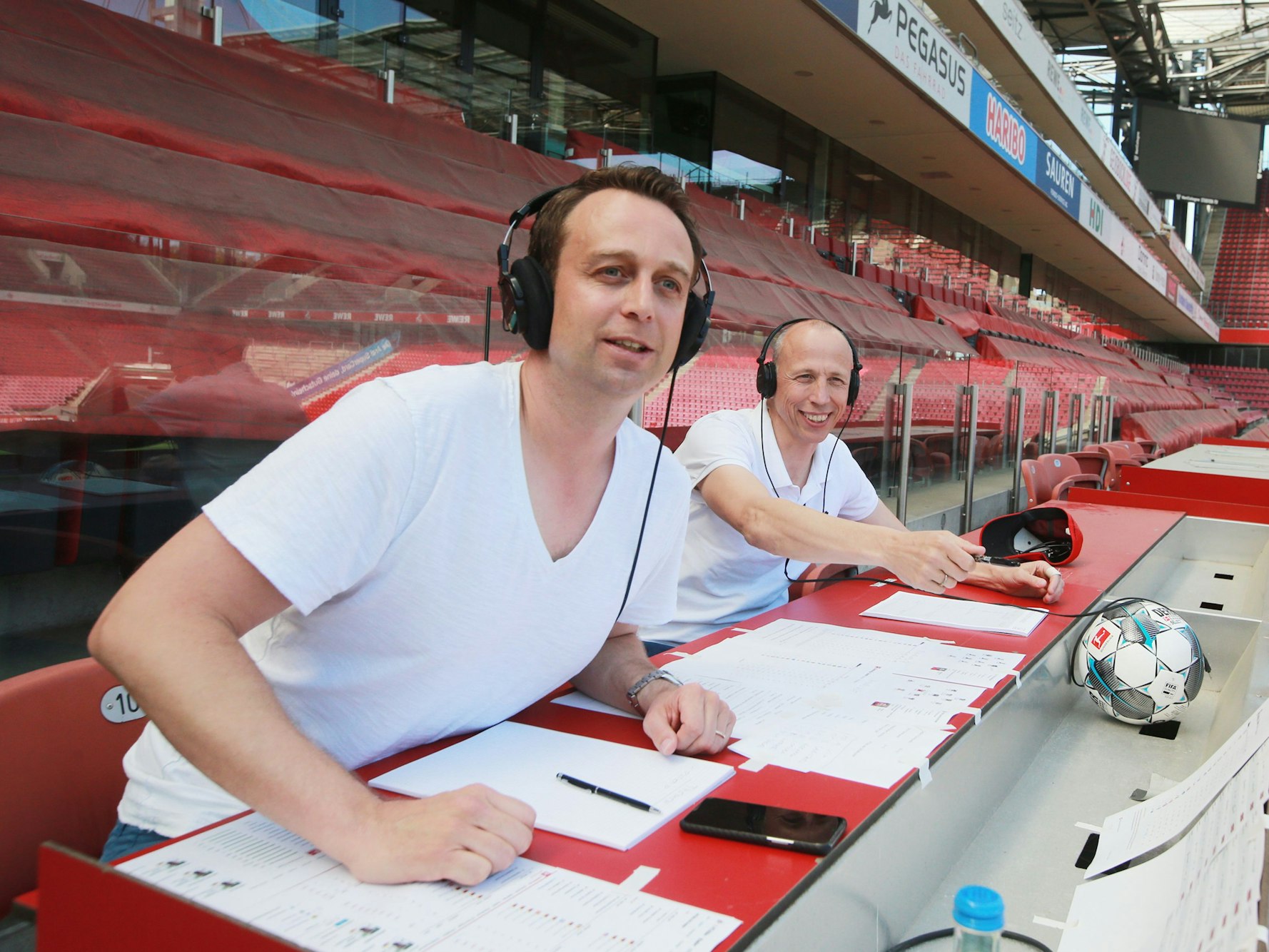 Lukas Wachten und Matthias Scherz als Moderator und Kommentator im Rhein-Energie-Stadion in Köln.