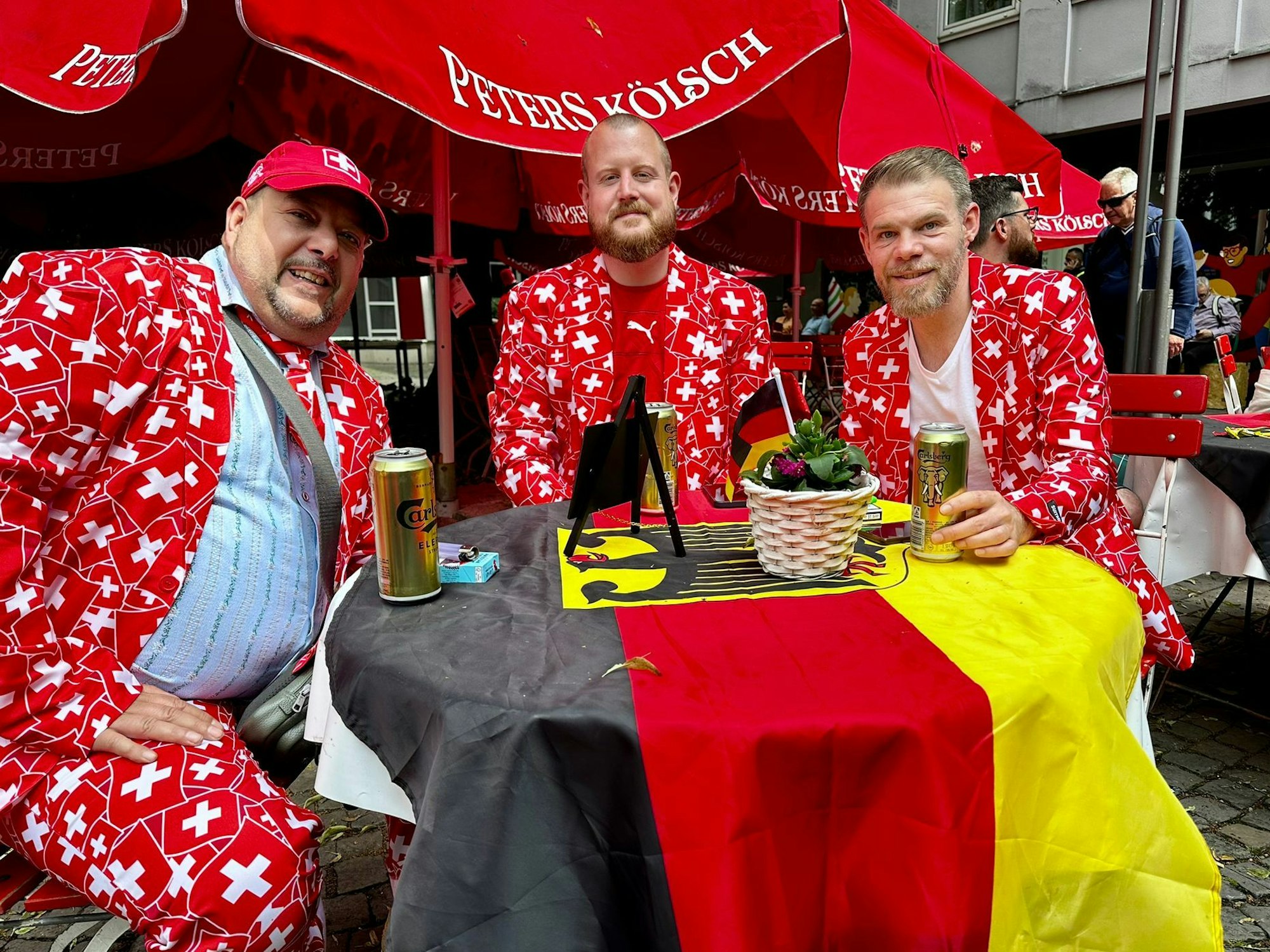 Die Schweizer Sylvain, Laurent und Philippe sitzen in einer Kneipe in Köln.