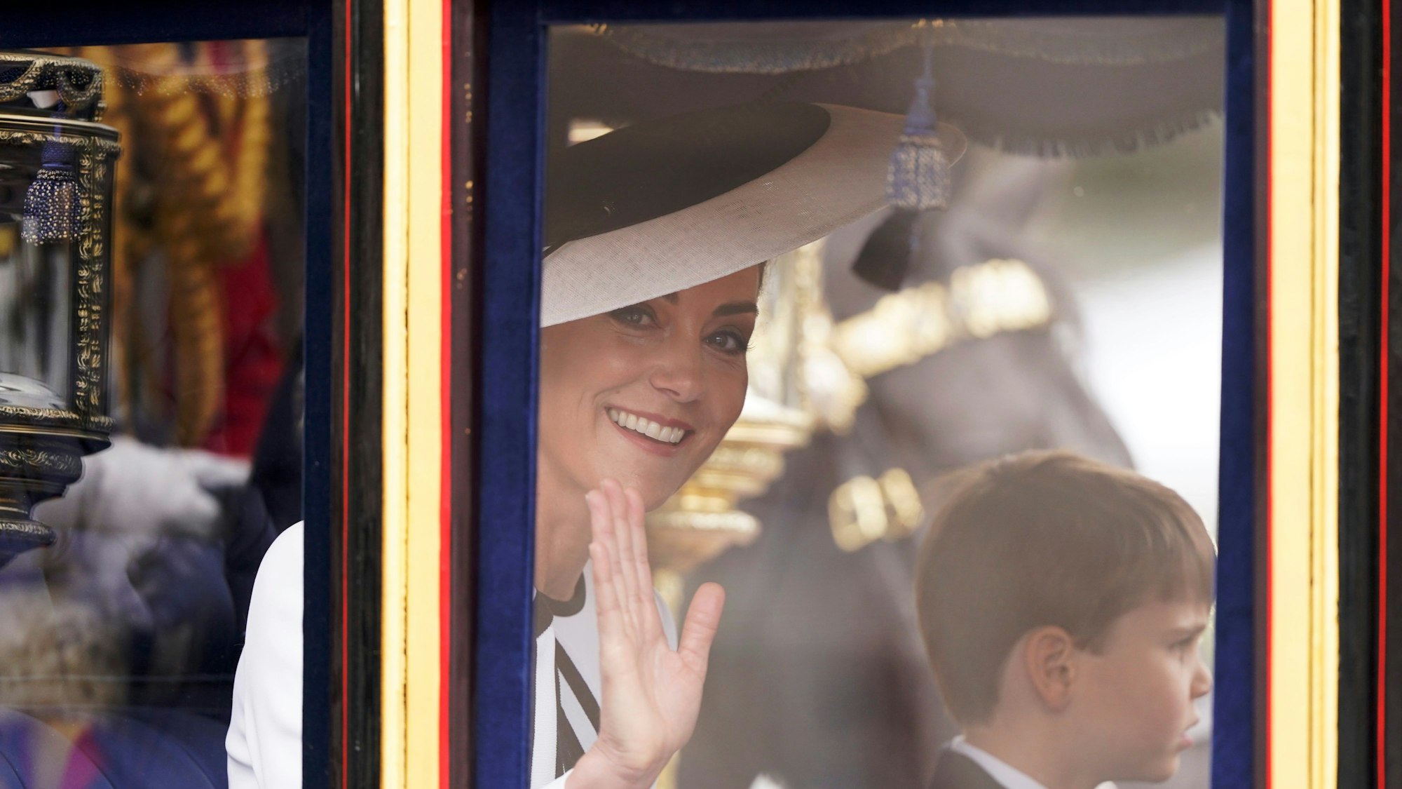 Prinzessin Kate auf dem Weg zur Horse Guards Parade in London, neben ihr Prinz Louis: Ein Experte hat nun die geheime Botschaft ihres Outfits entschlüsselt.