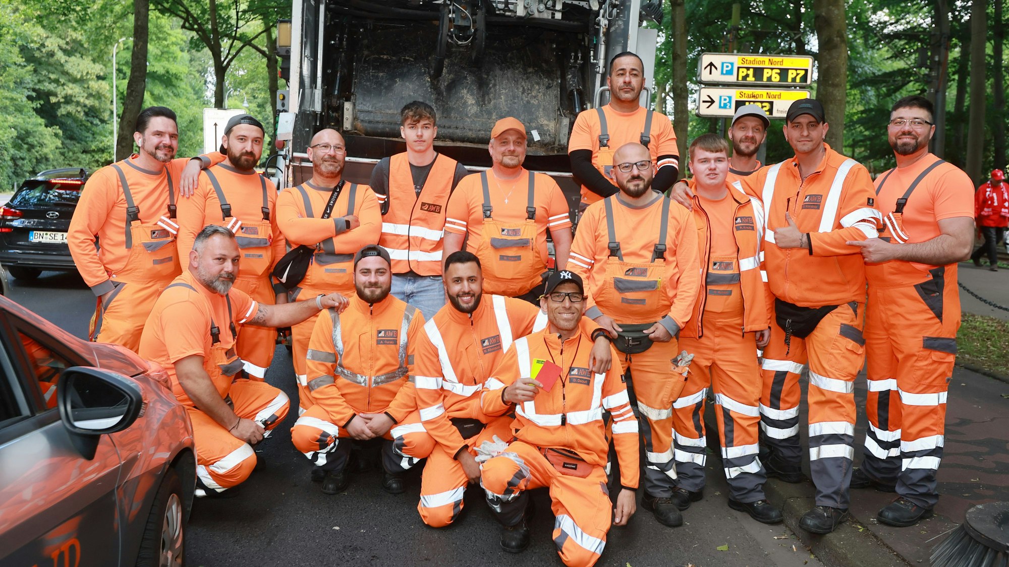AWB-Trupp mit ca. 15 Männern in orangenen Anzügen.