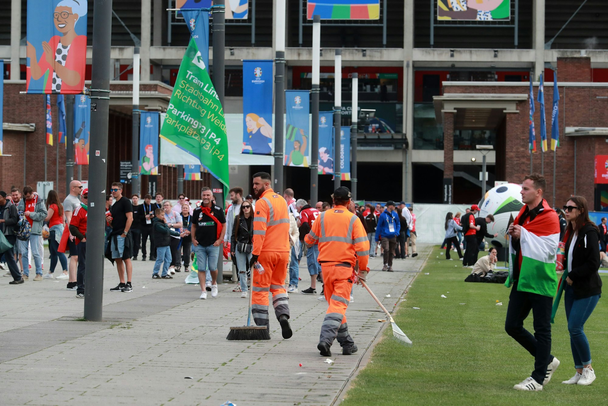 Arbeiter der AWB sind vor dem Kölner Stadion innerhalb der Fanmassen von Ungarn und der Schweiz zu sehen.