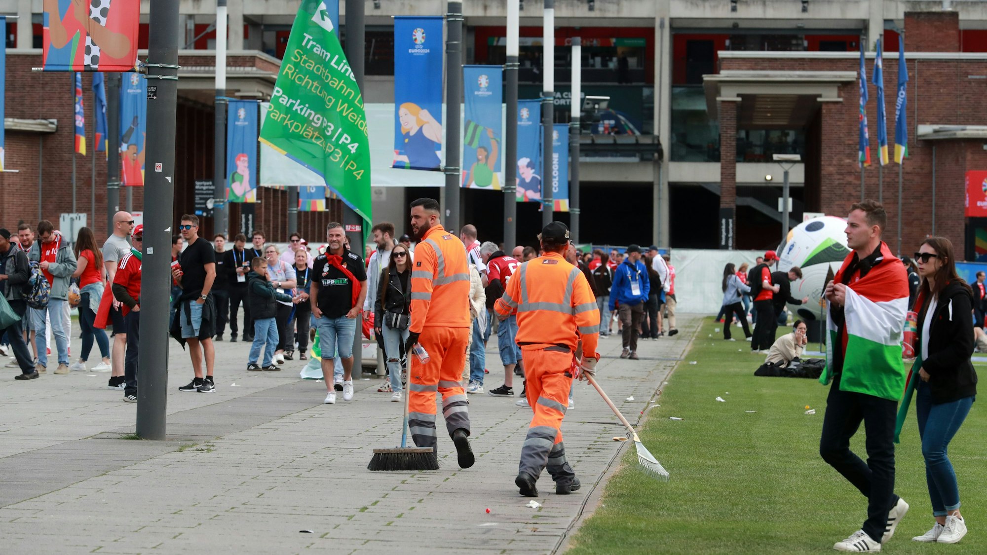 Arbeiter der AWB sind vor dem Kölner Stadion innerhalb der Fanmassen von Ungarn und der Schweiz zu sehen.