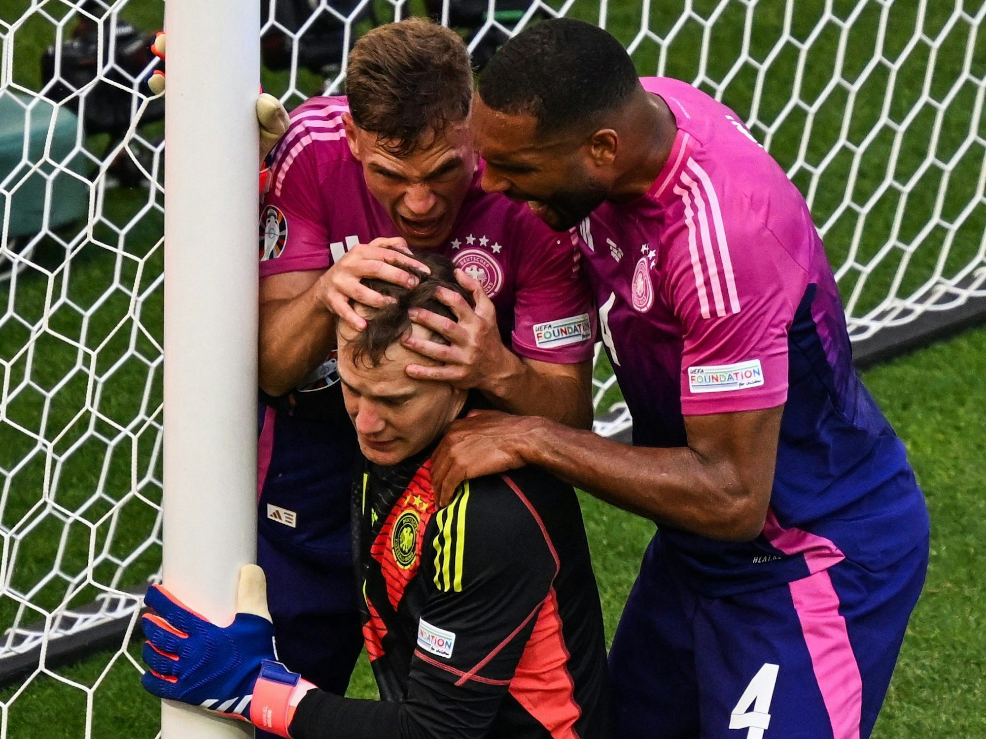 Deutschlands Joshua Kimmich (l) und Deutschlands Jonathan Tah (r) mit Deutschlands Torhüter Manuel Neuer nach einer Parade.