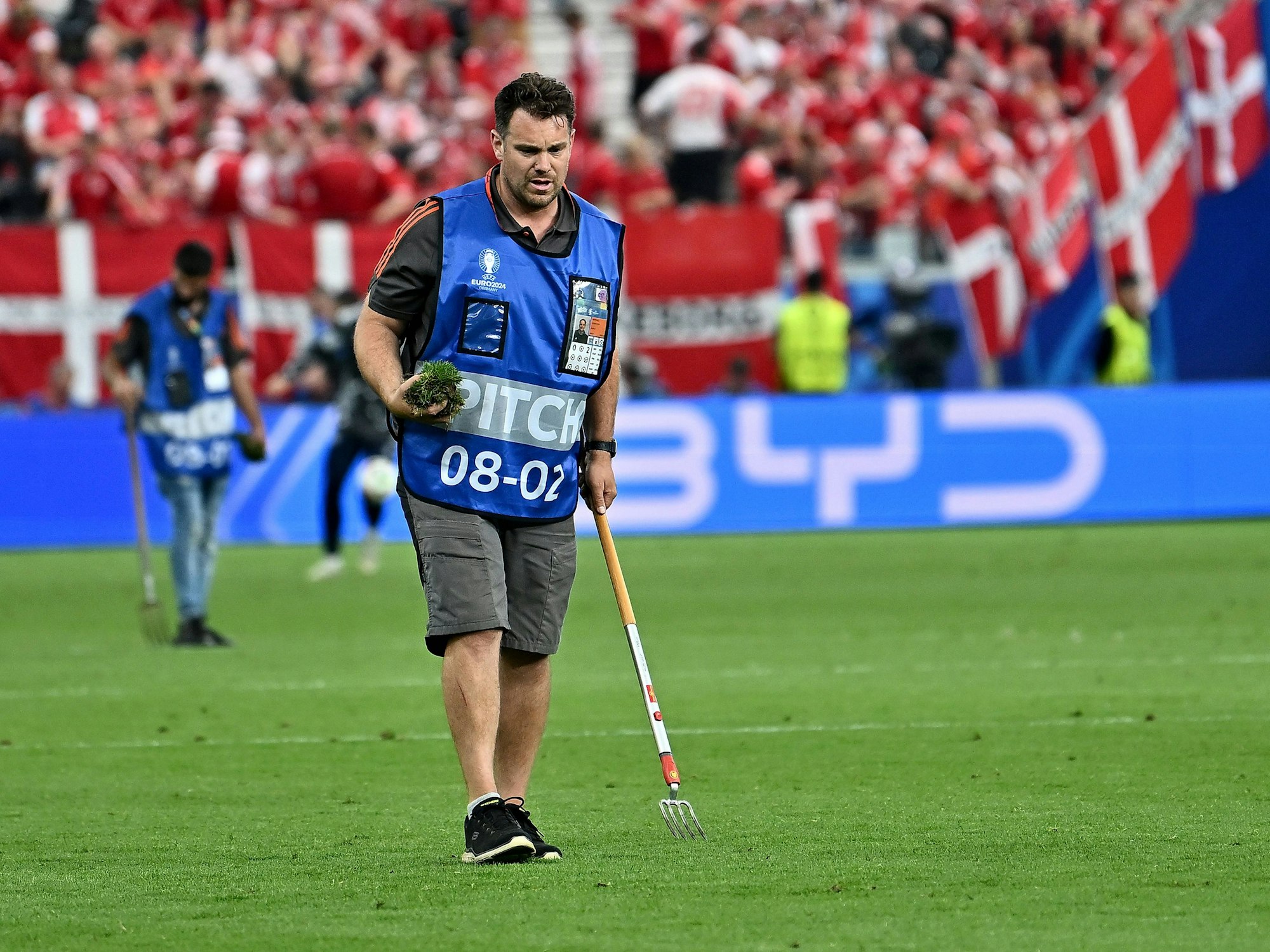 Greenkeeper kümmert sich um den lädierten Rasen.