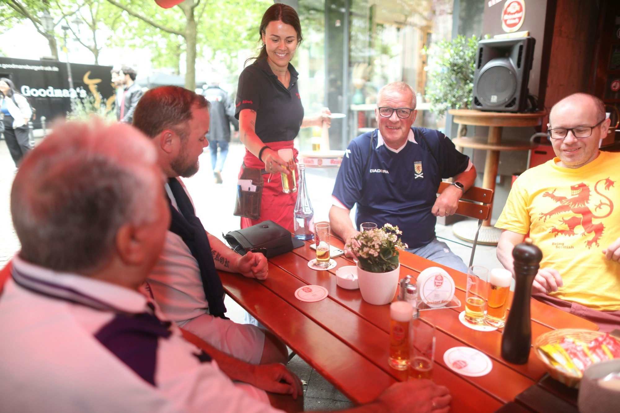 Eine Gruppe Fußballfans sitzt in einem Brauhaus.