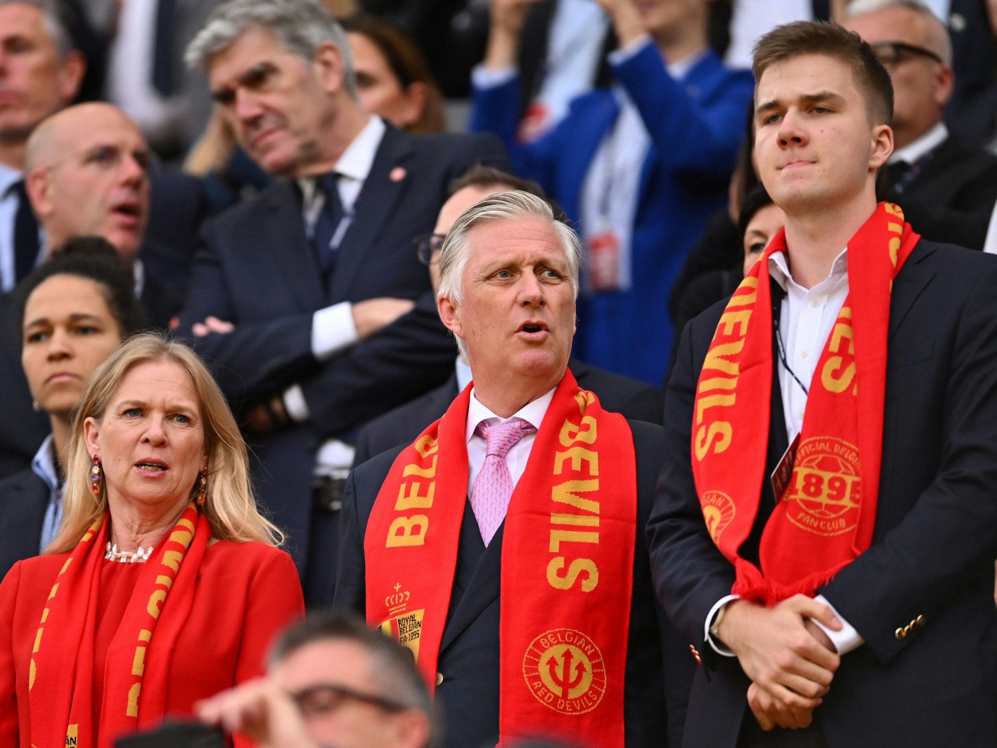 Belgiens König Philippe (M) und Prinz Emmanuel stehen auf der Tribüne.