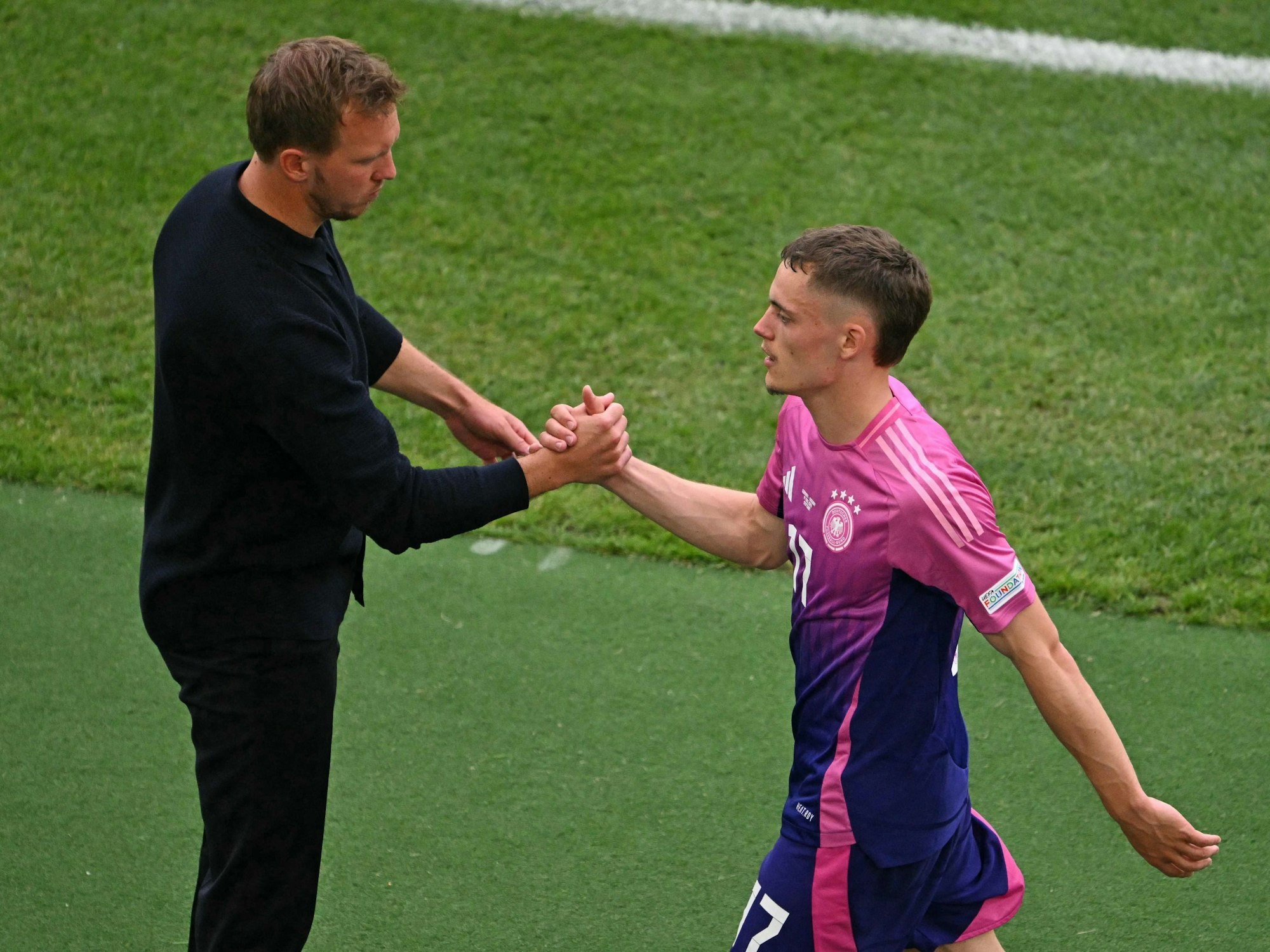 Bundestrainer Julian Nagelsmann schlägt mit Florian Wirtz nach dessen Auswechslung ein.