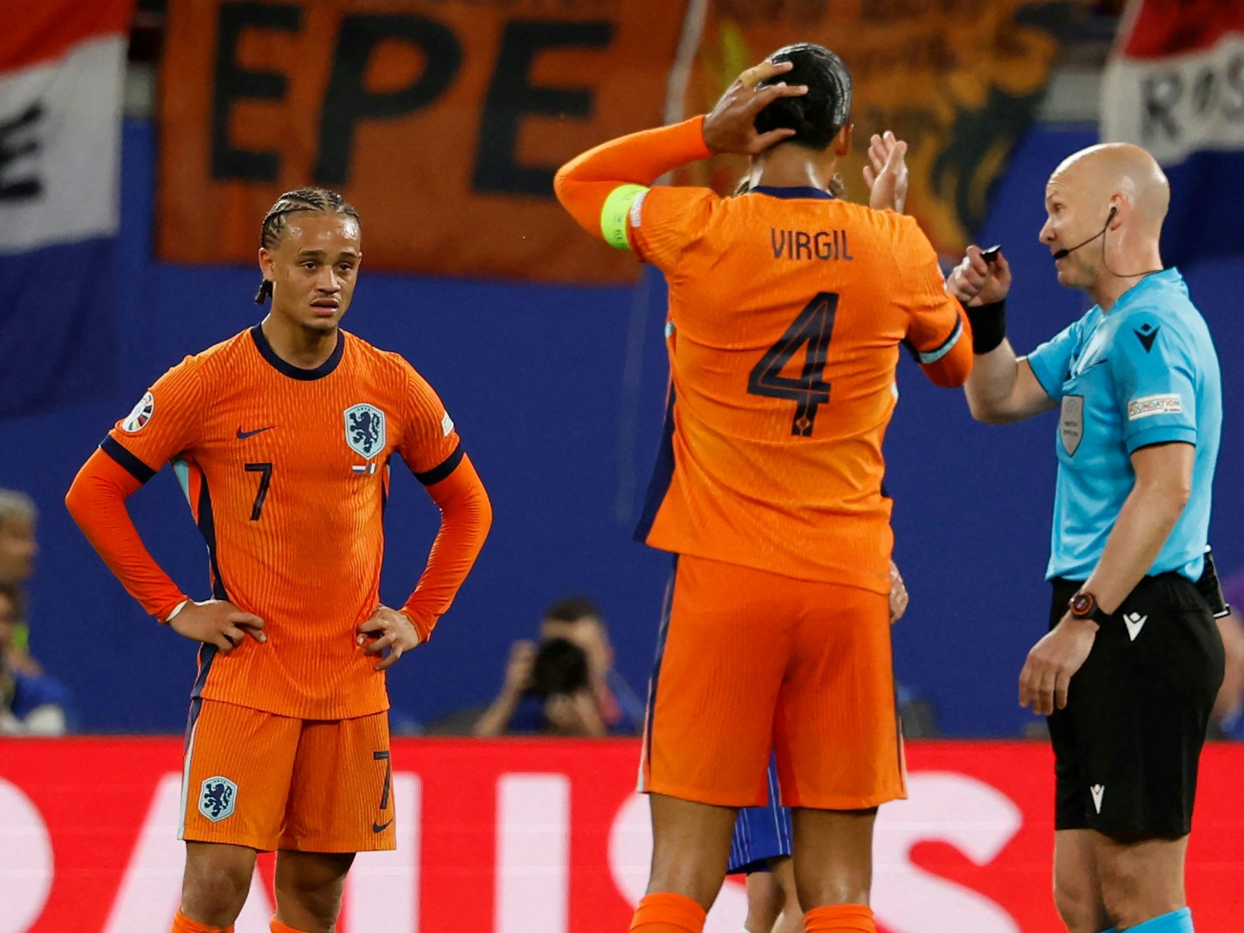 Xavi Simons guckt enttäuscht, während Schiedsrichter Anthony Taylor dem Oranje-Kapitän Virgil van Dijk die Situation erklärt.