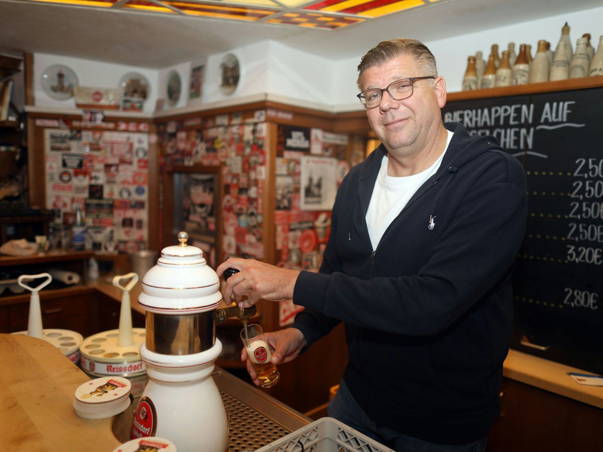 Martin Schlüter, Wirt vom Reissdorf am Hahnentor, steht an der Zapfanlage und zapft ein Kölsch.