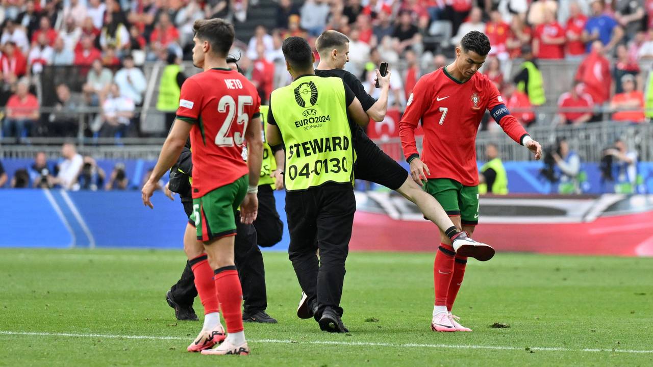 Ein Flitzer auf der Jagd nach Cristiano Ronaldo. Ordner greifen beim EM-Spiel zwischen Portugal und der Türkei ein.