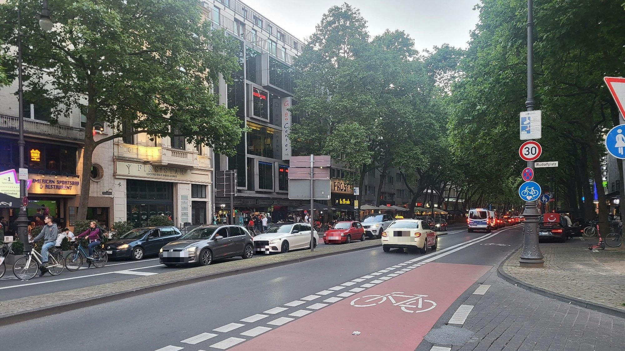 Fotos stehen auf dem Hohenzollernring in Köln und warten an einer roten Ampel.
