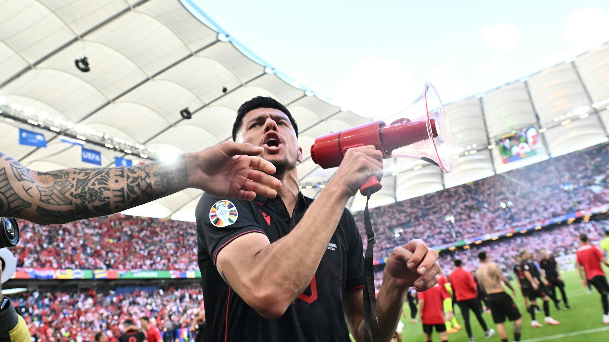 Mirlind Daku nach dem EM-Spiel zwischen Albanien und Kroatien mit einem Megafon in der Hand.