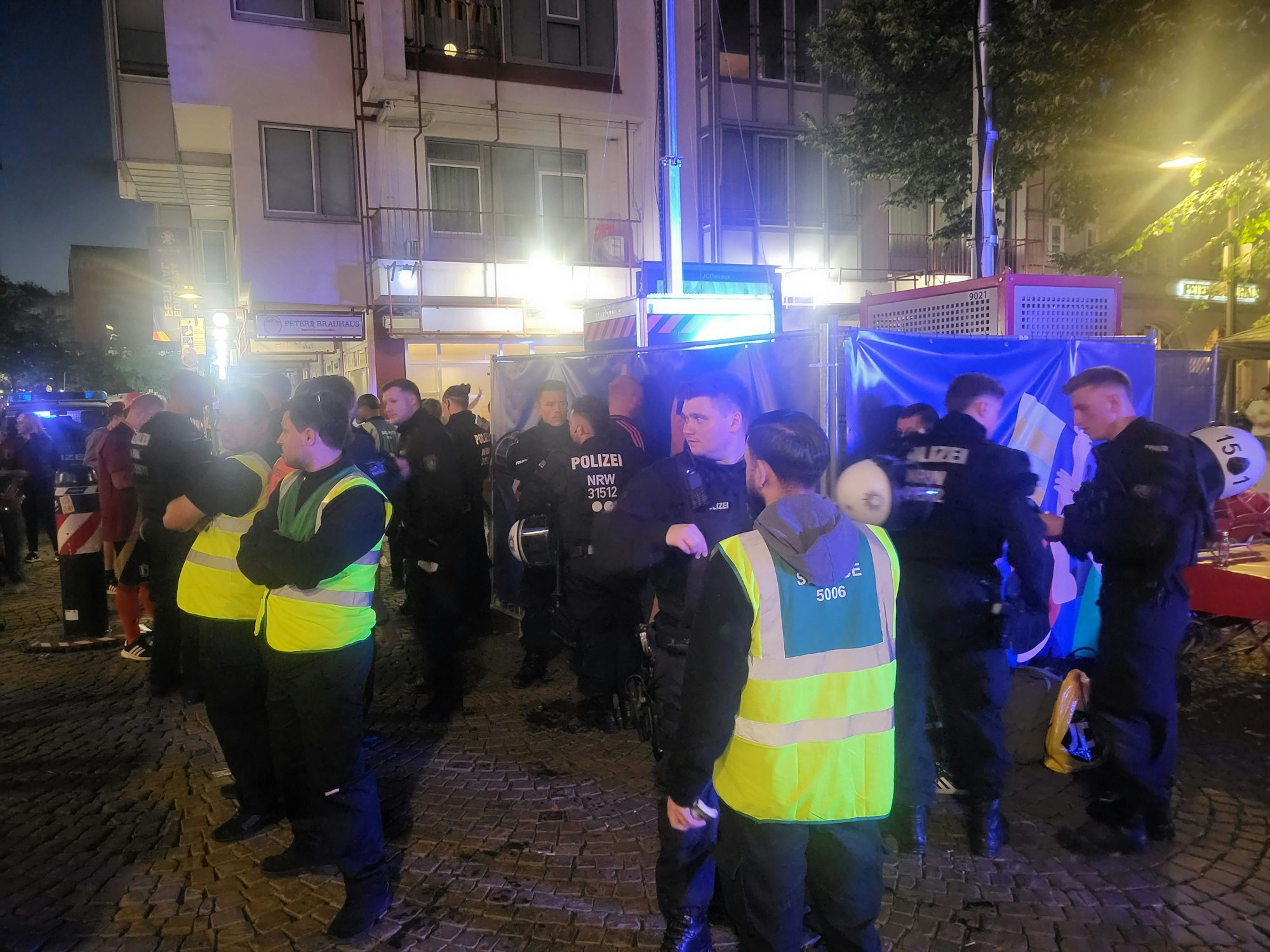 Polizei und Sicherheitsmitarbeiter bewachen einen Ort am Kölner Heumarkt.