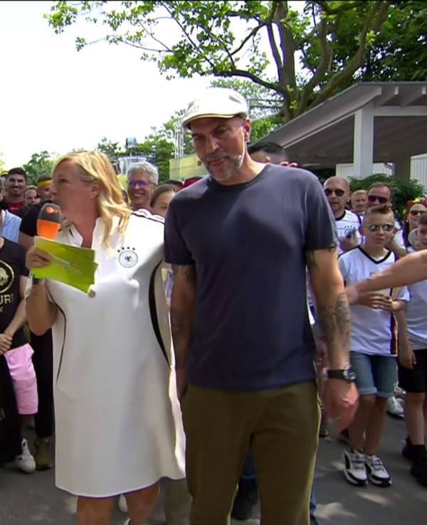 Das Foto stammt aus dem ZDF-Fernsehgarten und zeigt Markus Babbel (r.), Moderatorin Andrea Kiewel (2.v.r.) sowie Mario Basler (2.v.l.) mit einem weiblichen Fan (l.), der gerade von einem Security-Mitarbeiter am Arm gepackt wird.