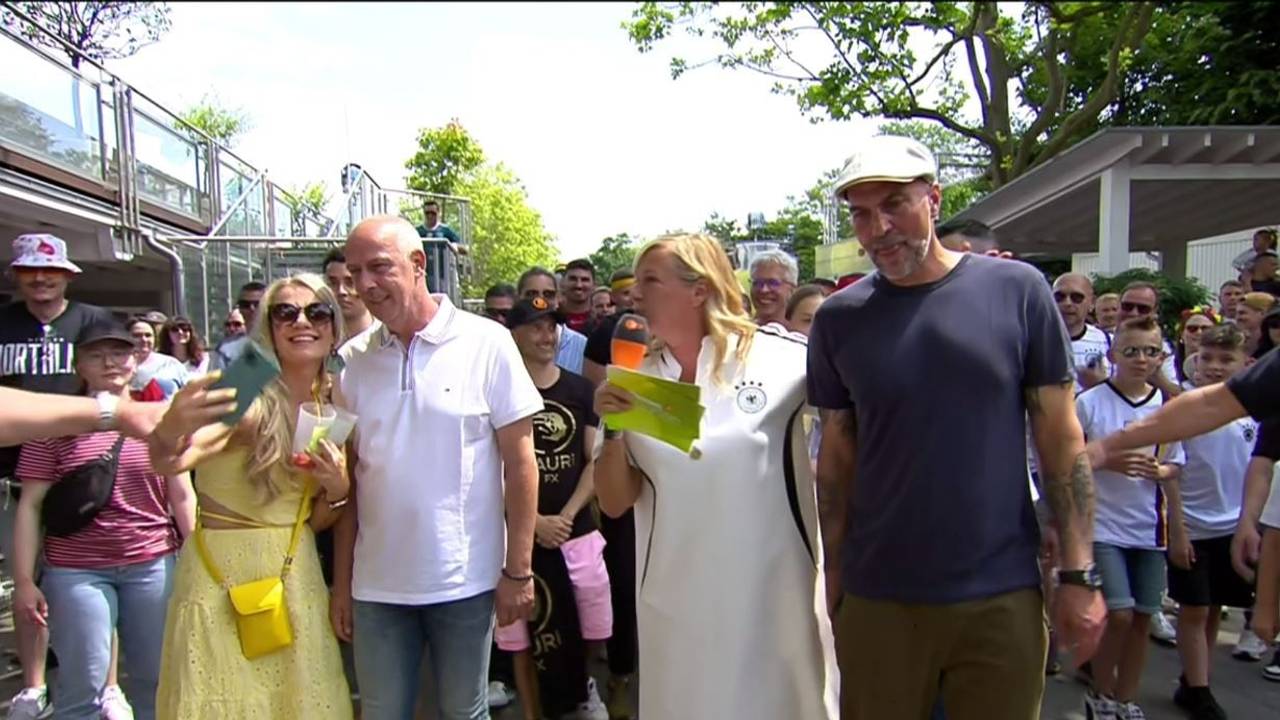 Das Foto stammt aus dem ZDF-Fernsehgarten und zeigt Markus Babbel (r.), Moderatorin Andrea Kiewel (2.v.r.) sowie Mario Basler (2.v.l.) mit einem weiblichen Fan (l.), der gerade von einem Security-Mitarbeiter am Arm gepackt wird.